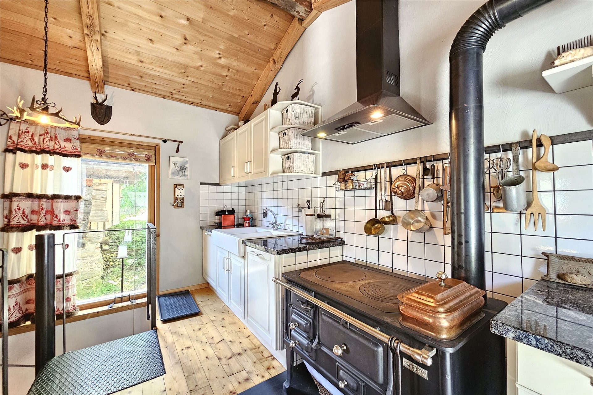 Gemütliche Landhausküche mit Holzdecke und Holzofen
