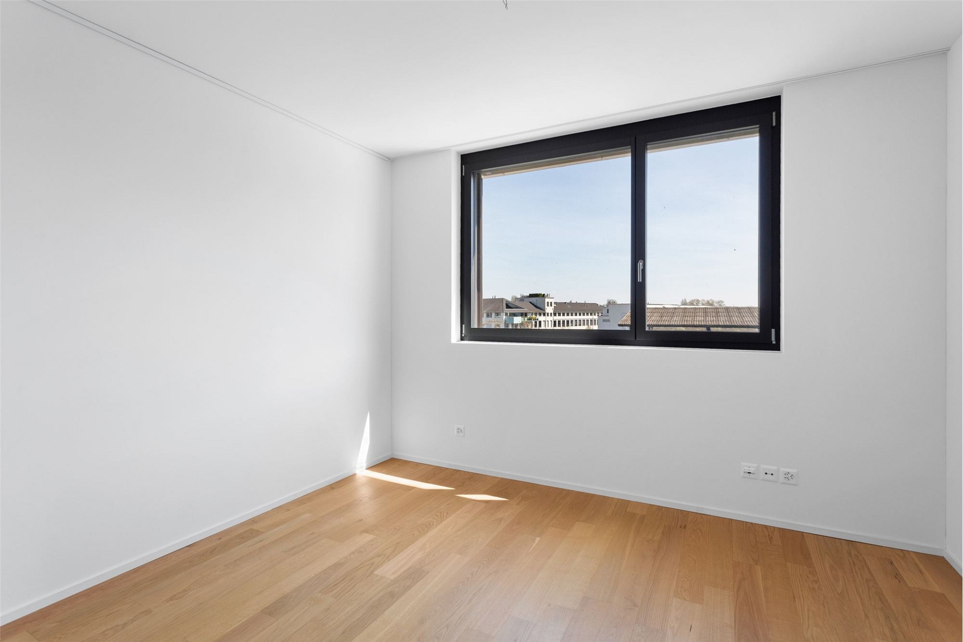 Helles, leeres Zimmer mit großem Fenster