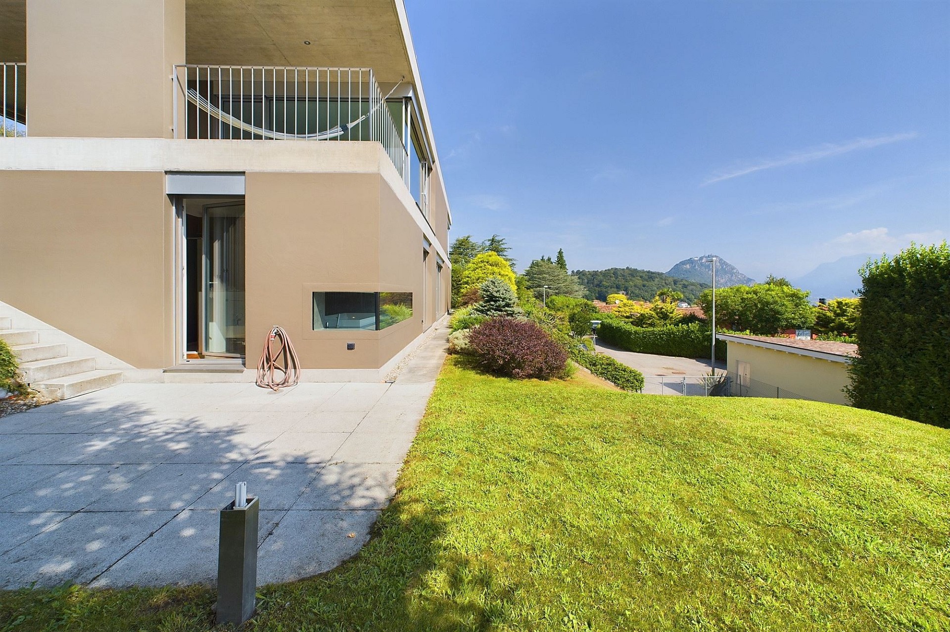Moderne Hausfassade mit Garten und Bergblick