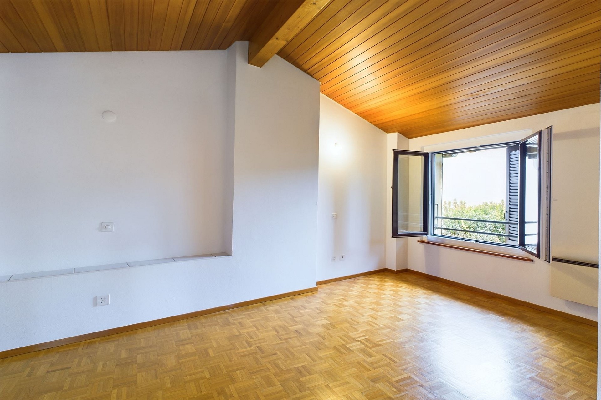 Leerer Wohnraum mit Holzdecke und Parkett