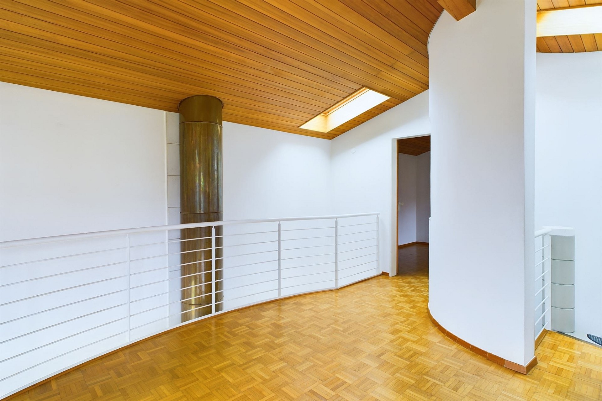 Lichtes Treppenpodest mit Holzdecke