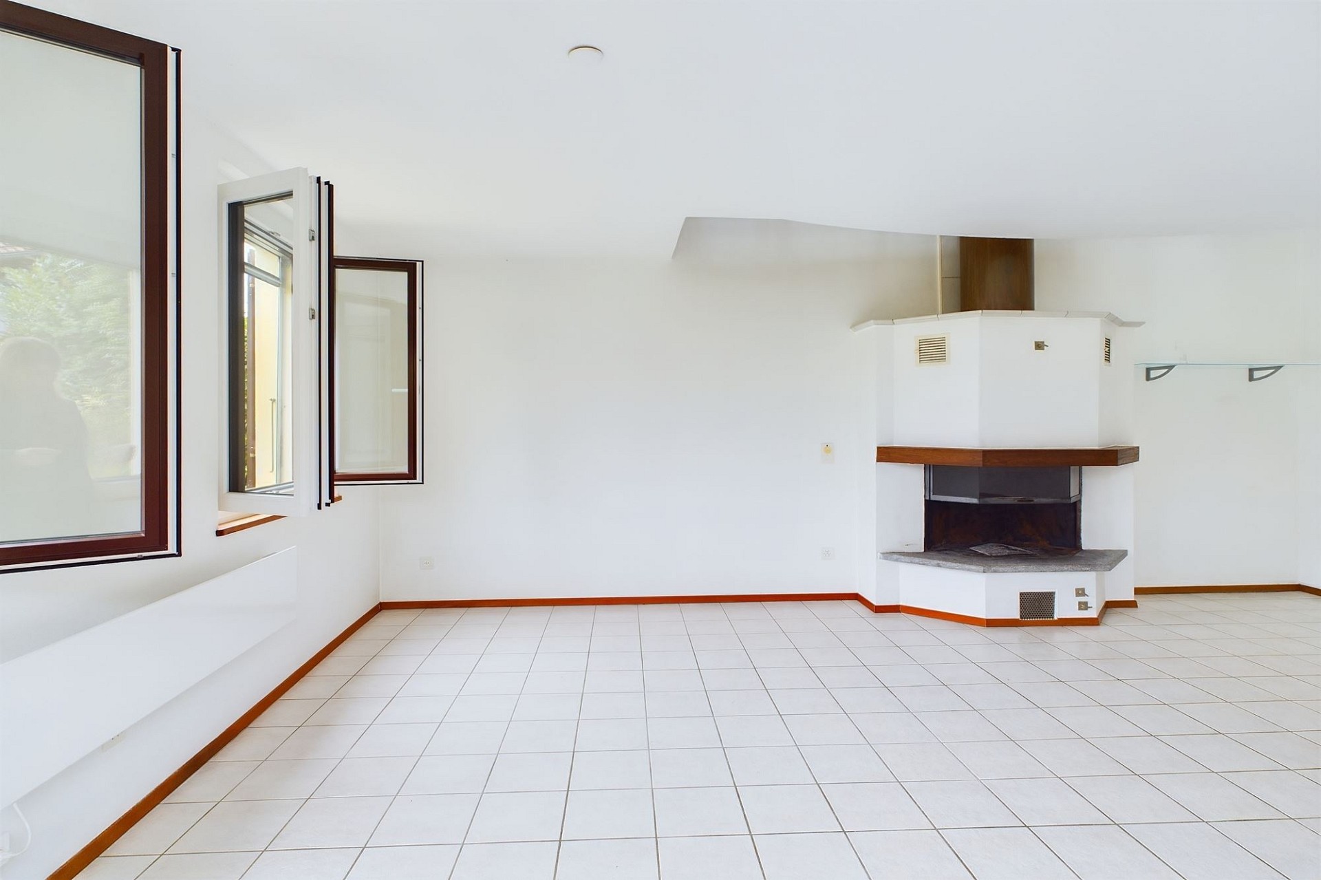 Heller Wohnraum mit Kamin und Fliesenboden
