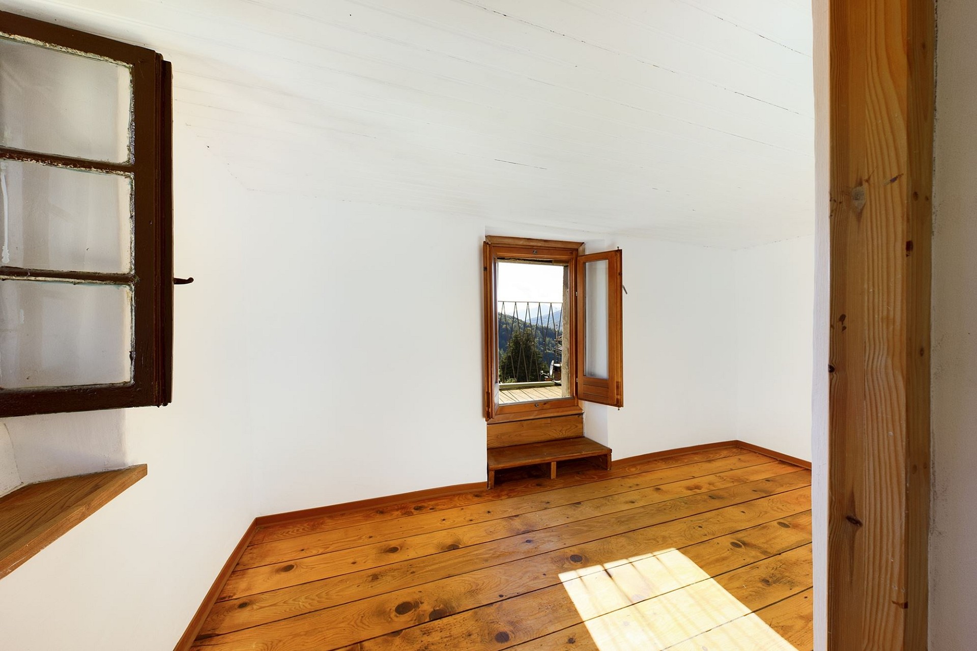 Helles Zimmer mit Holzboden und Fensterblick