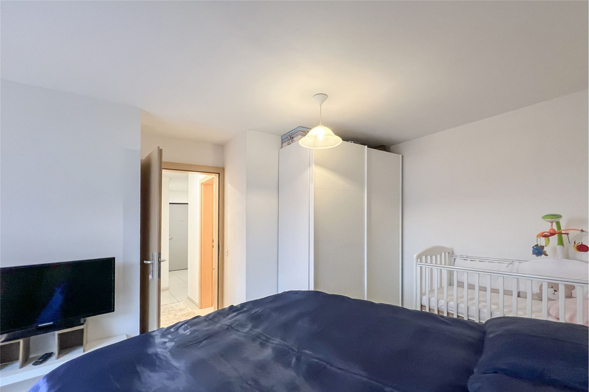 Schlafzimmer mit Kinderbett und Kleiderschrank