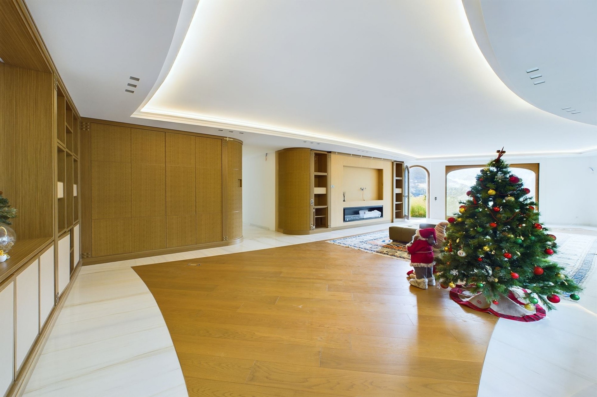 Großer Wohnraum mit geschwungener Decke und Weihnachtsbaum