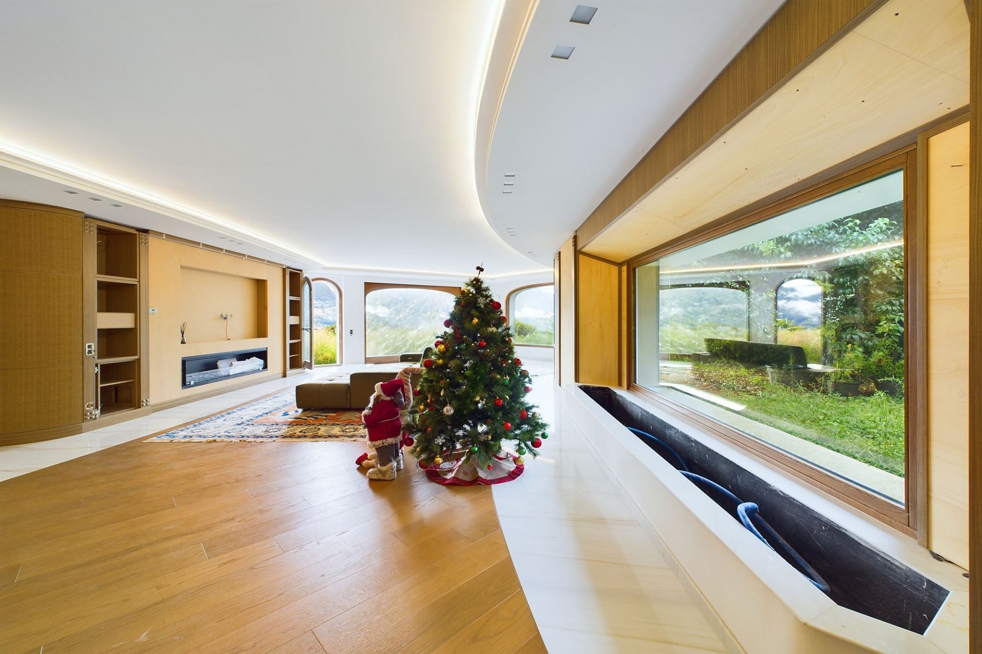 Großer moderner Wohnraum mit Panoramafenstern und Weihnachtsbaum