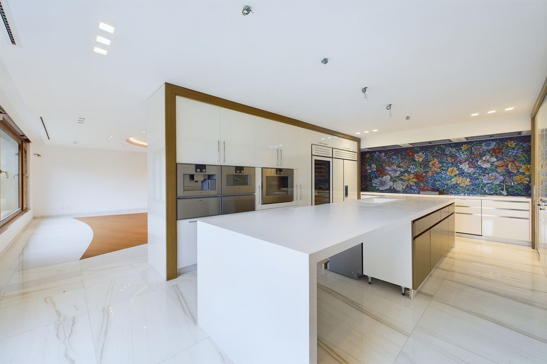 Moderne offene Küche mit Insel und farbiger Rückwand