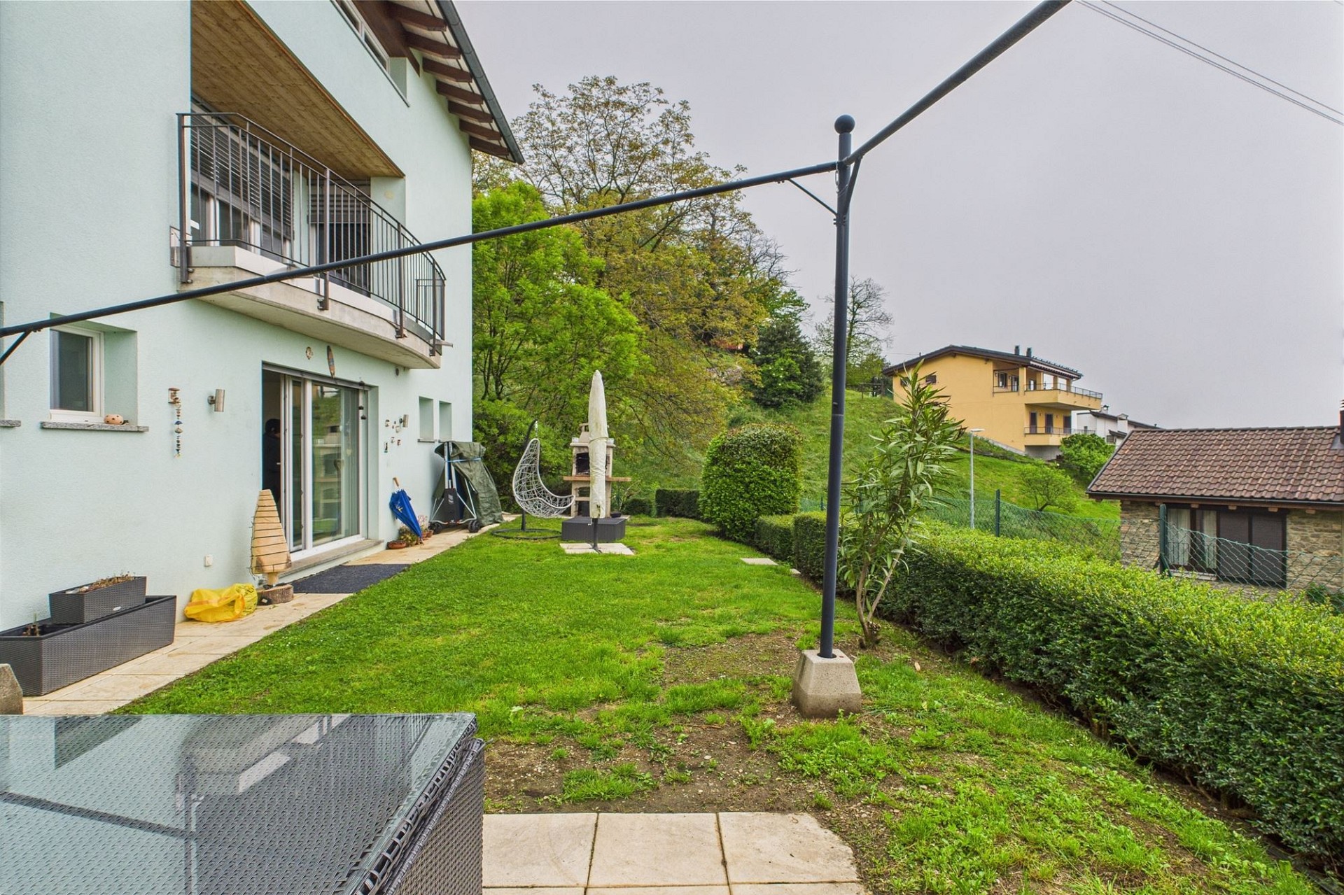 Gartenansicht eines Wohnhauses mit Balkon
