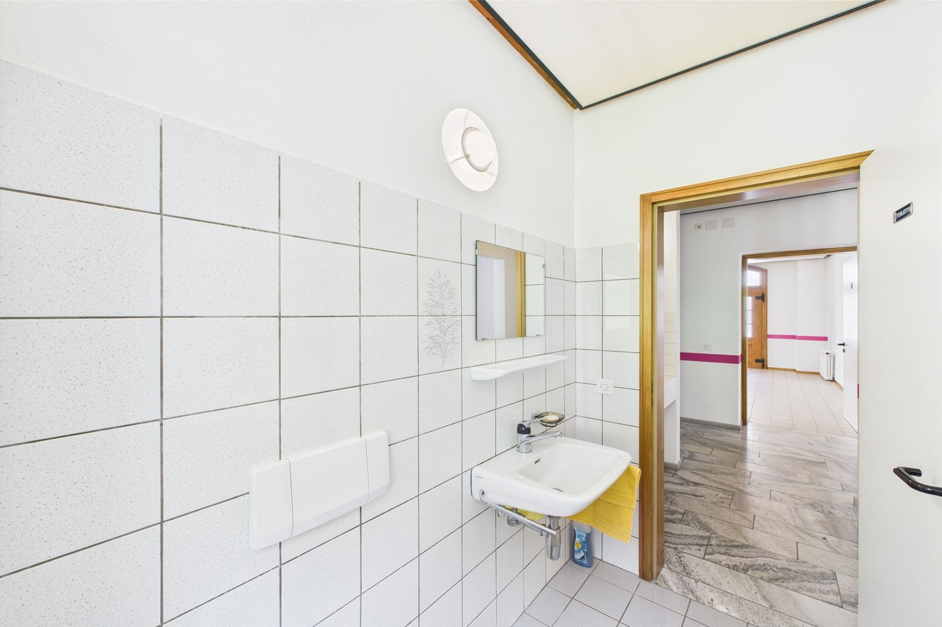 Helles Badezimmer mit Waschtisch und Flurblick