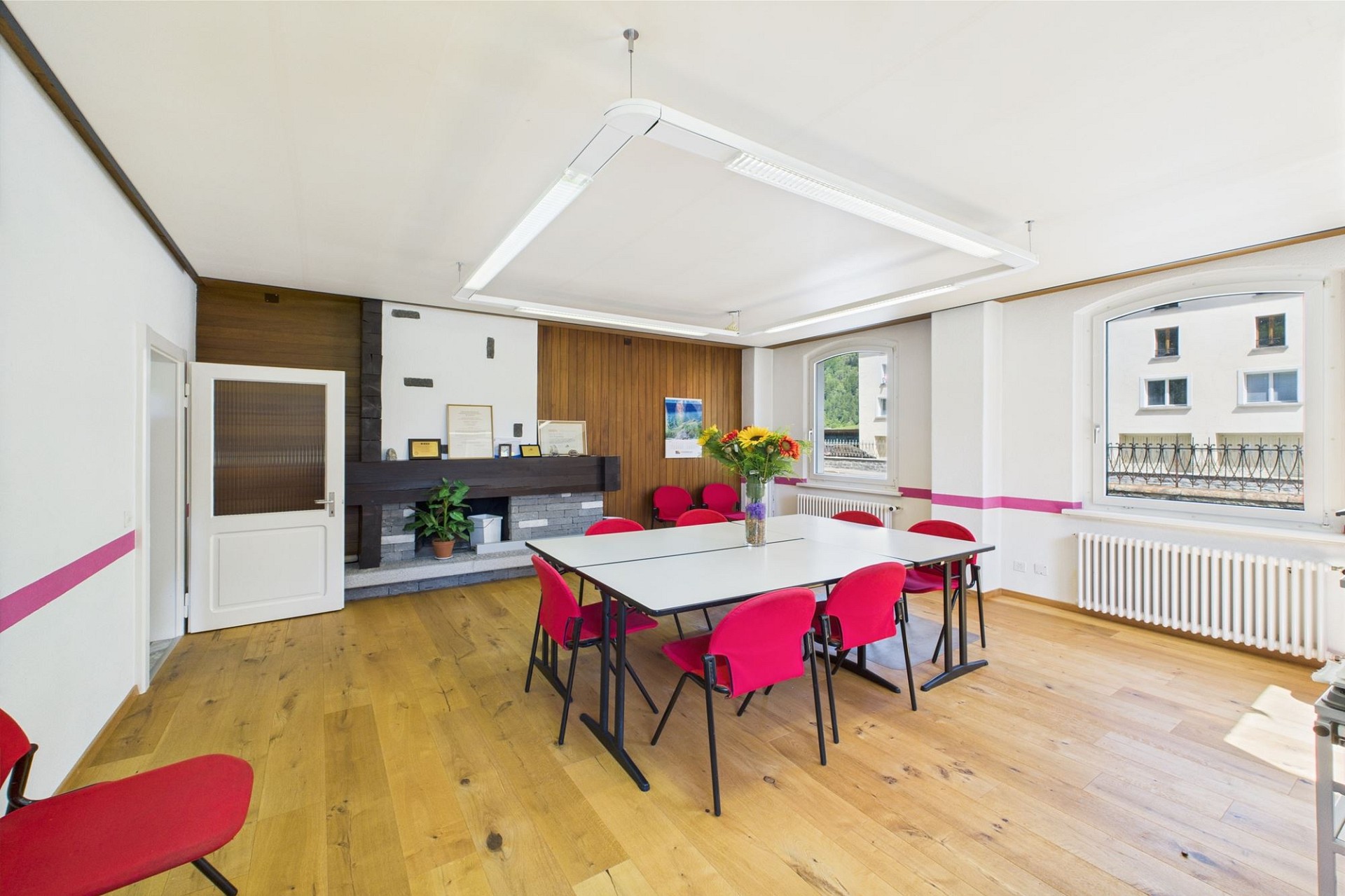 Heller Besprechungsraum mit Tisch und Kamin