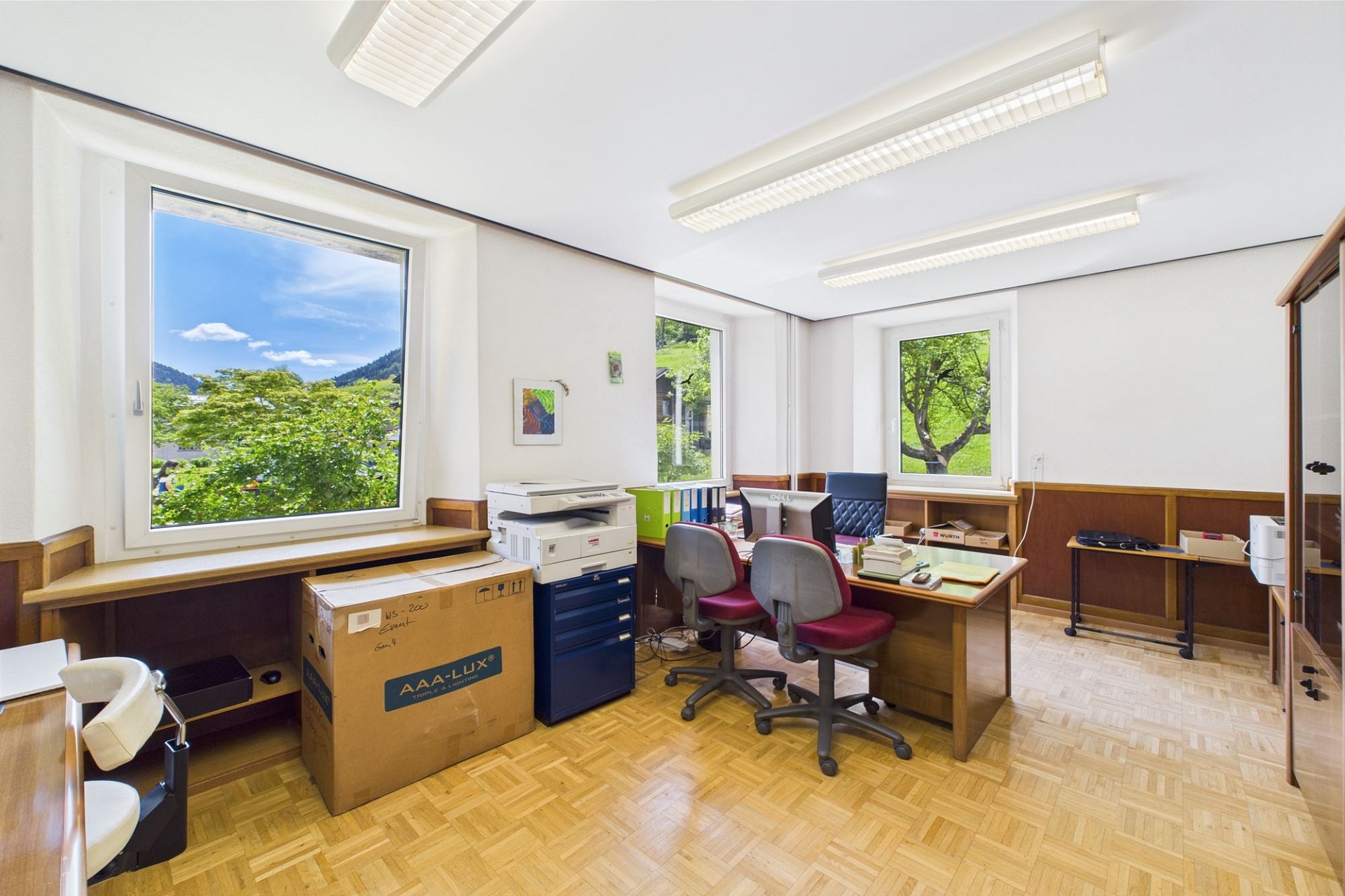 Helles Büro mit großen Fenstern und Gartenblick
