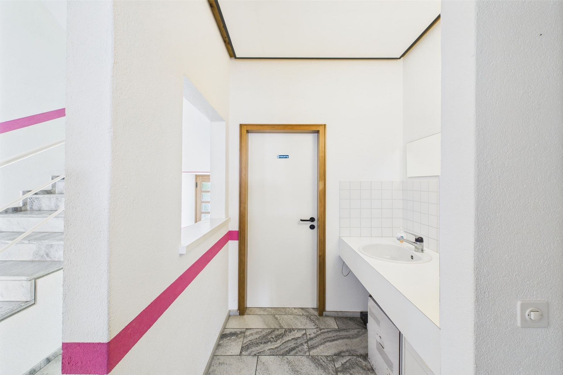 Heller Flur mit Treppenaufgang und WC-Tür