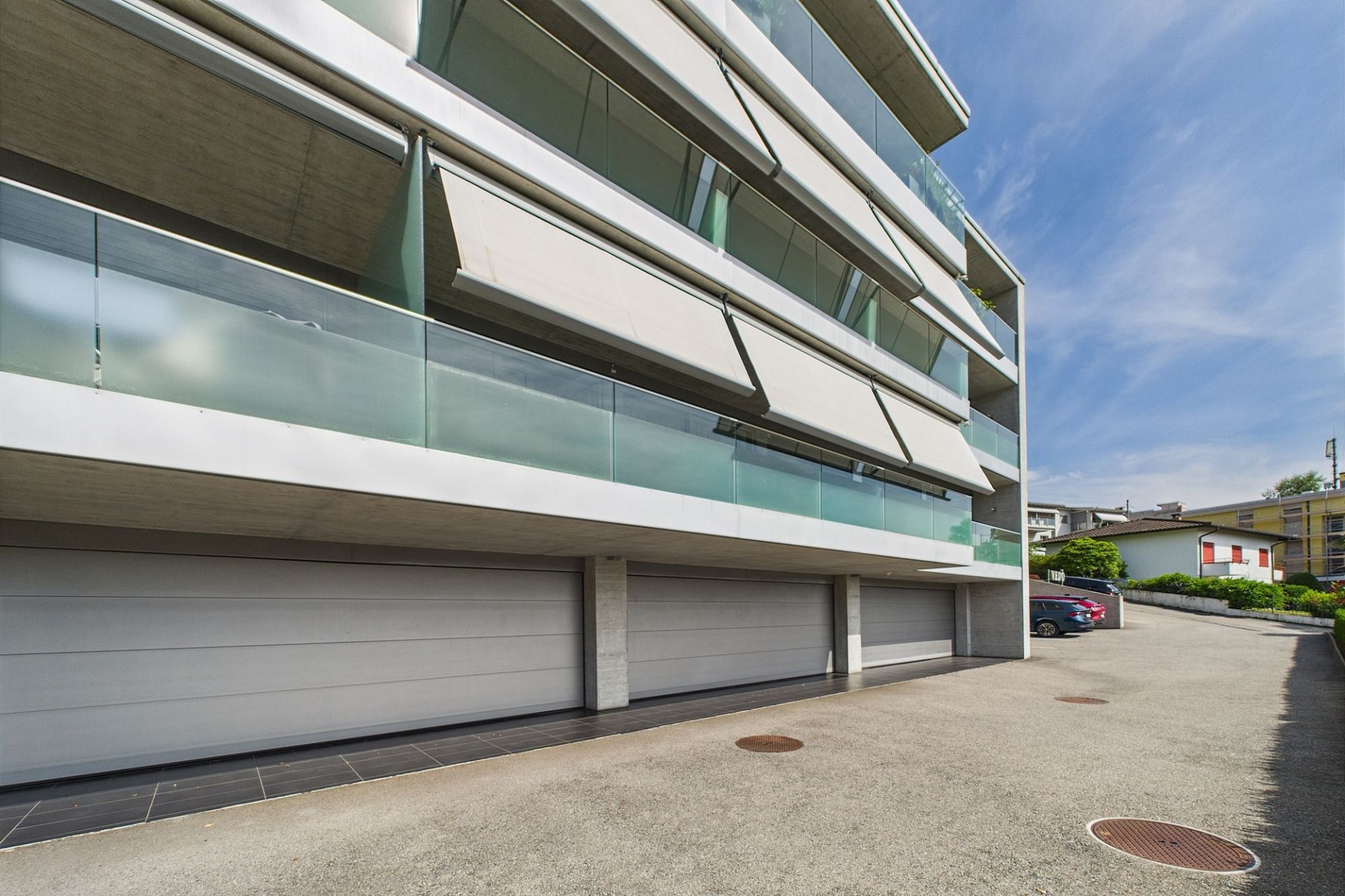 Moderne Wohnanlage mit Balkonen und Garagenzufahrt