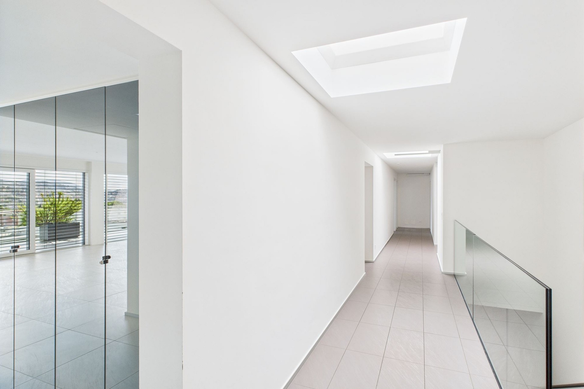 Heller Flur mit Galerie und Glasgeländer