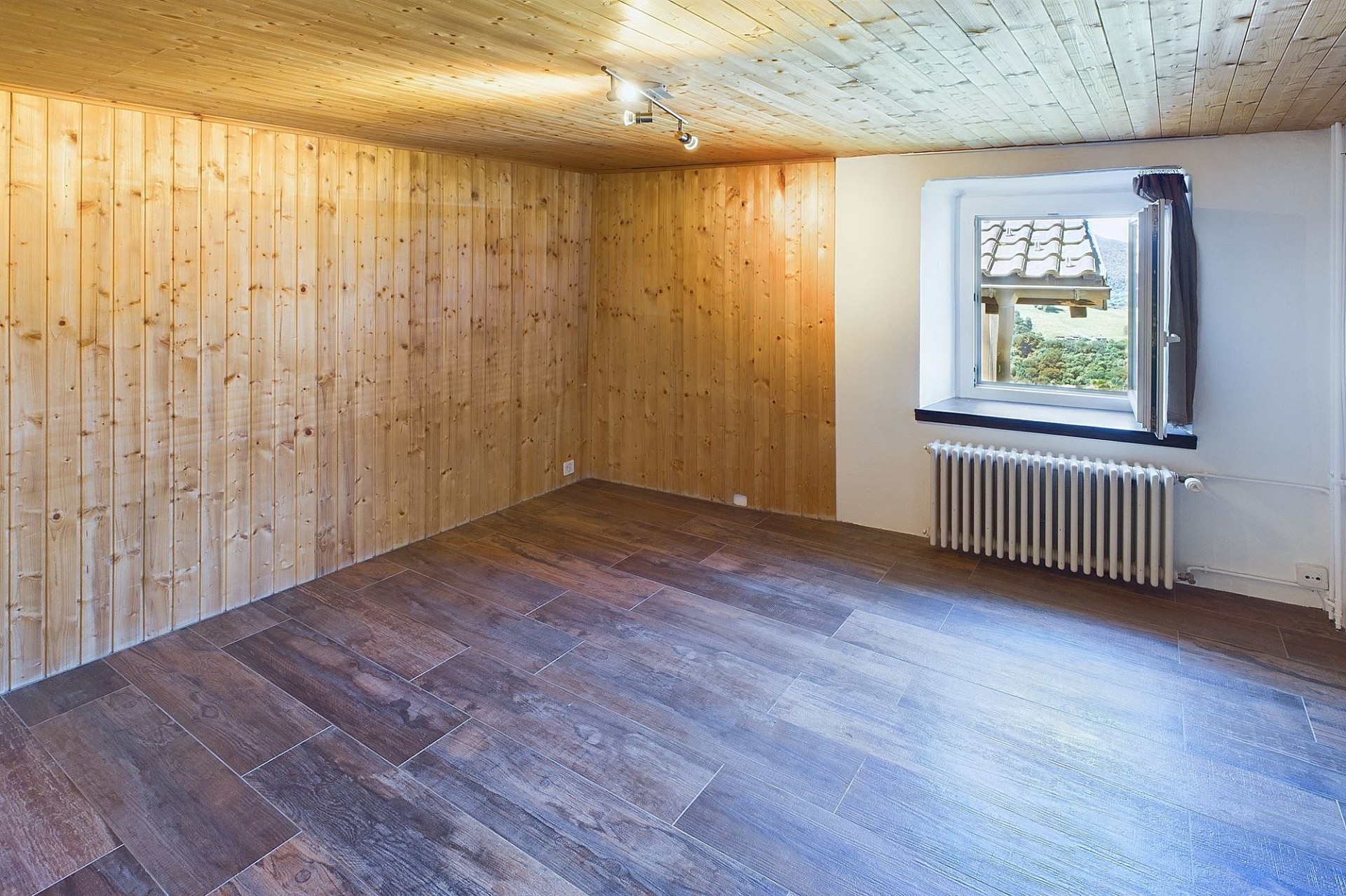 Leerer Raum mit Holzverkleidung und Blick ins Grüne