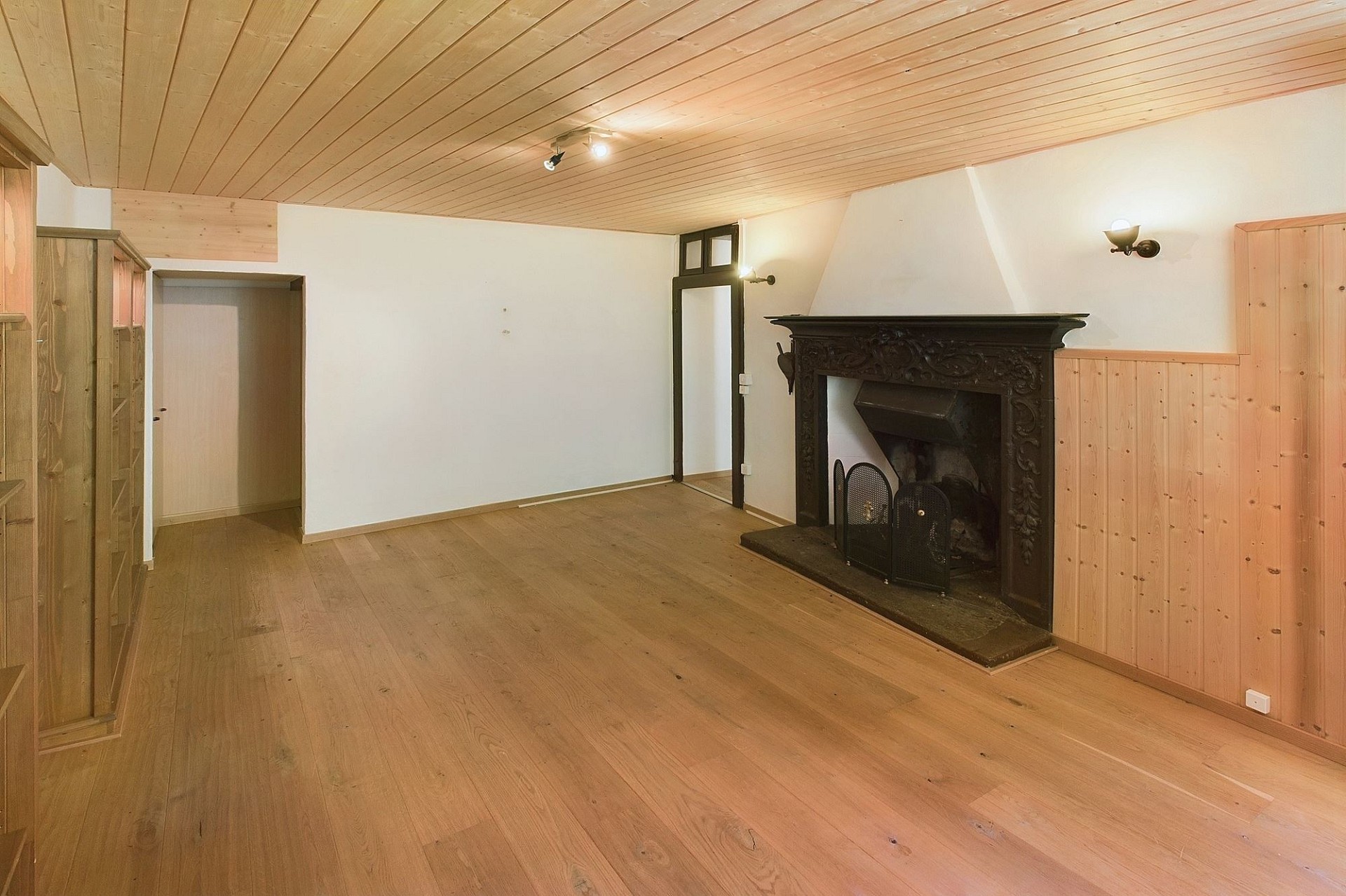 Leerer Wohnraum mit Kamin und Holzausstattung