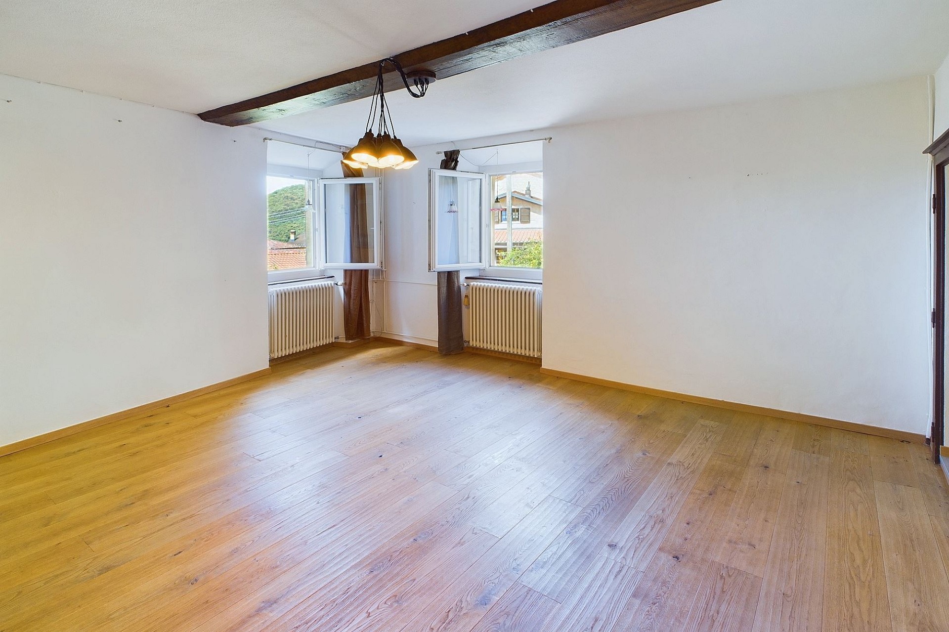Leeres Zimmer mit Parkett und zwei Fenstern