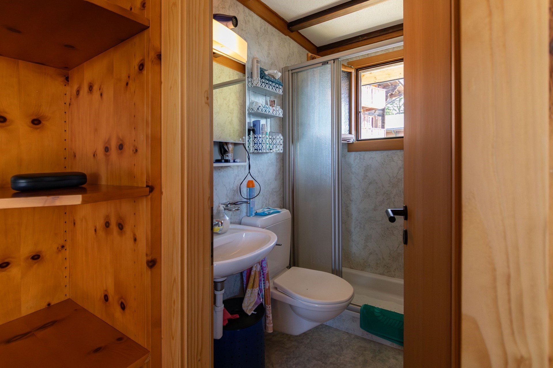 Kleines Bad mit Dusche und Holzregalen