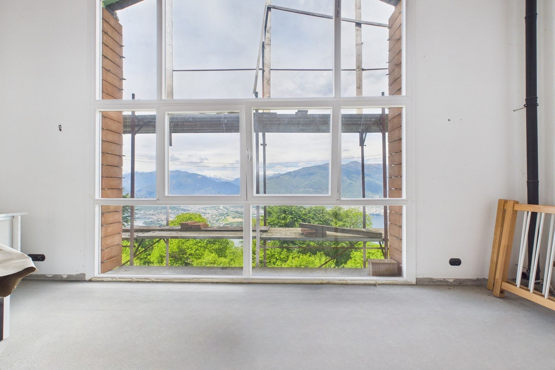 Großes Fenster mit Bergblick in einem unfertigen Innenraum