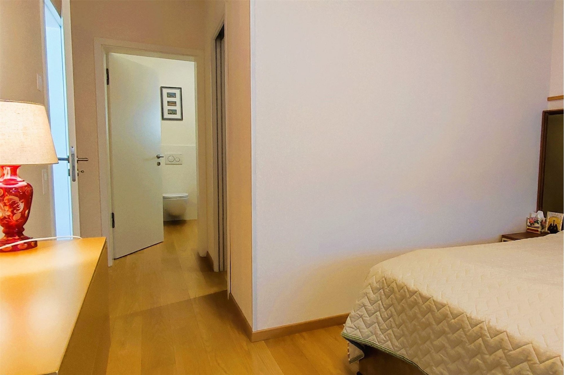 Helles Schlafzimmer mit Blick in einen angrenzenden Flur und ein Bad