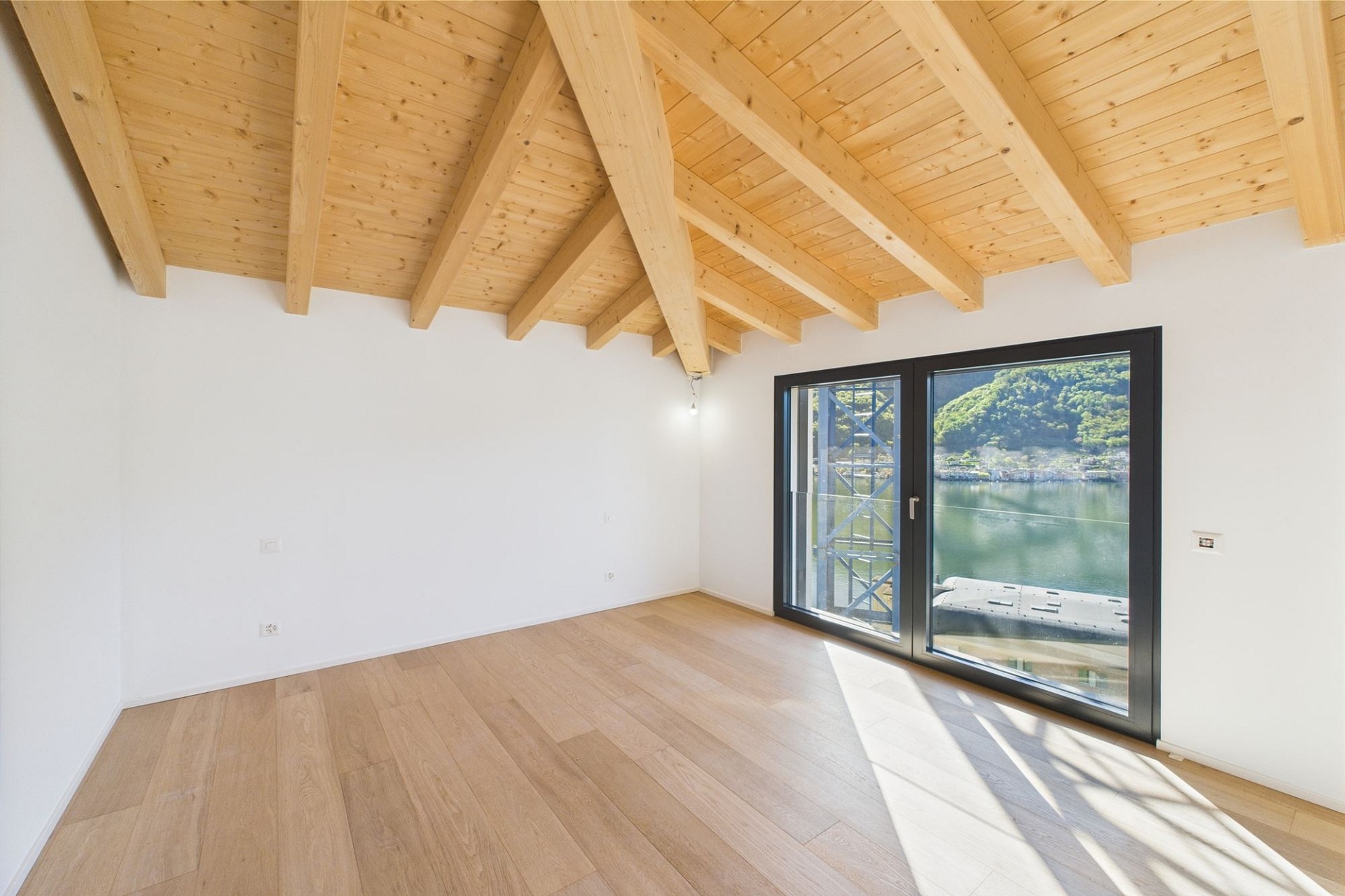 Helles Zimmer mit Holzbalkendecke und Seeblick