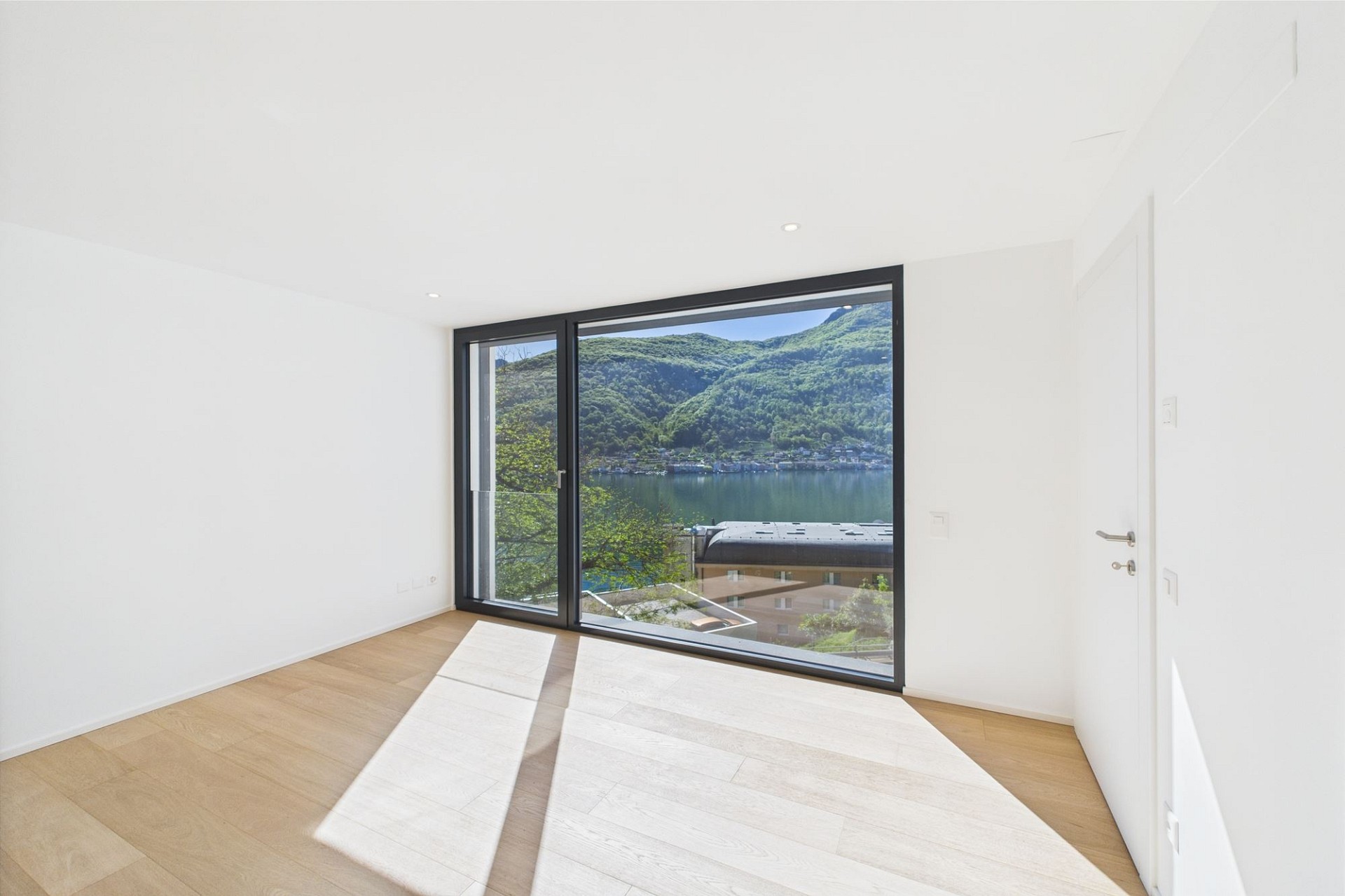Heller leerer Raum mit Panoramablick auf See und Berge