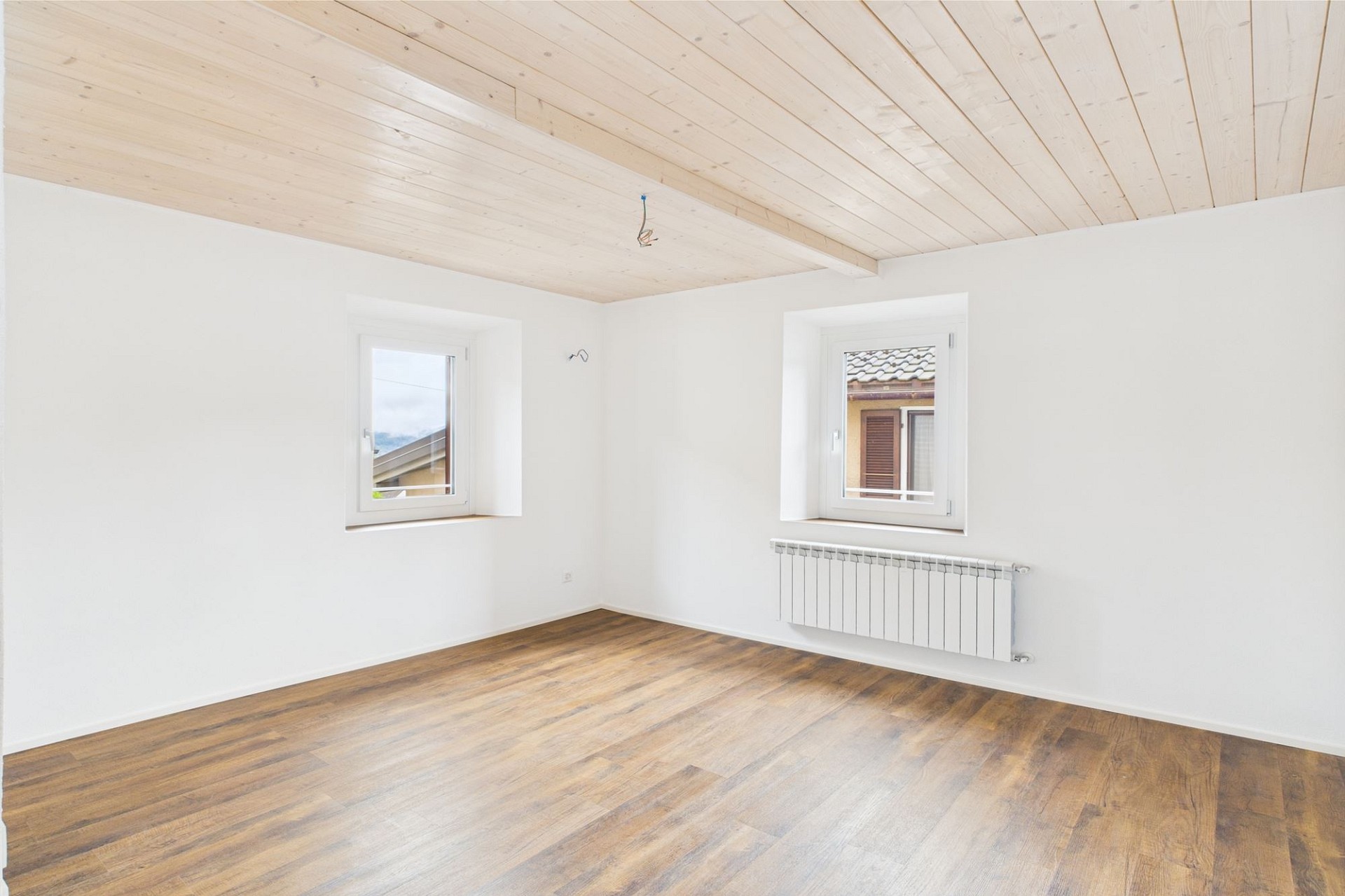 Heller leerer Raum mit Holzdecke und Holzboden