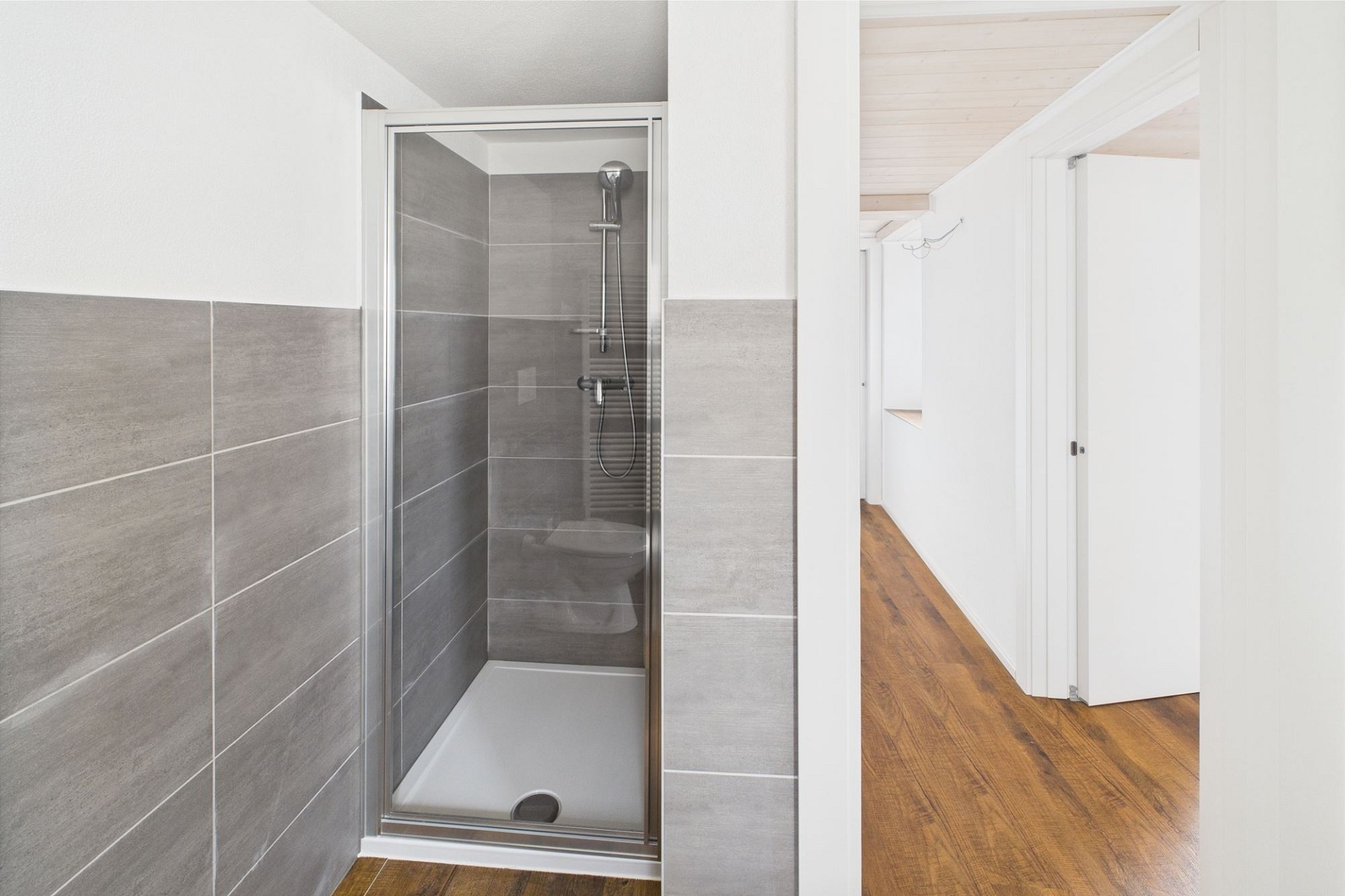 Modernes Badezimmer mit Duschbereich und Flur