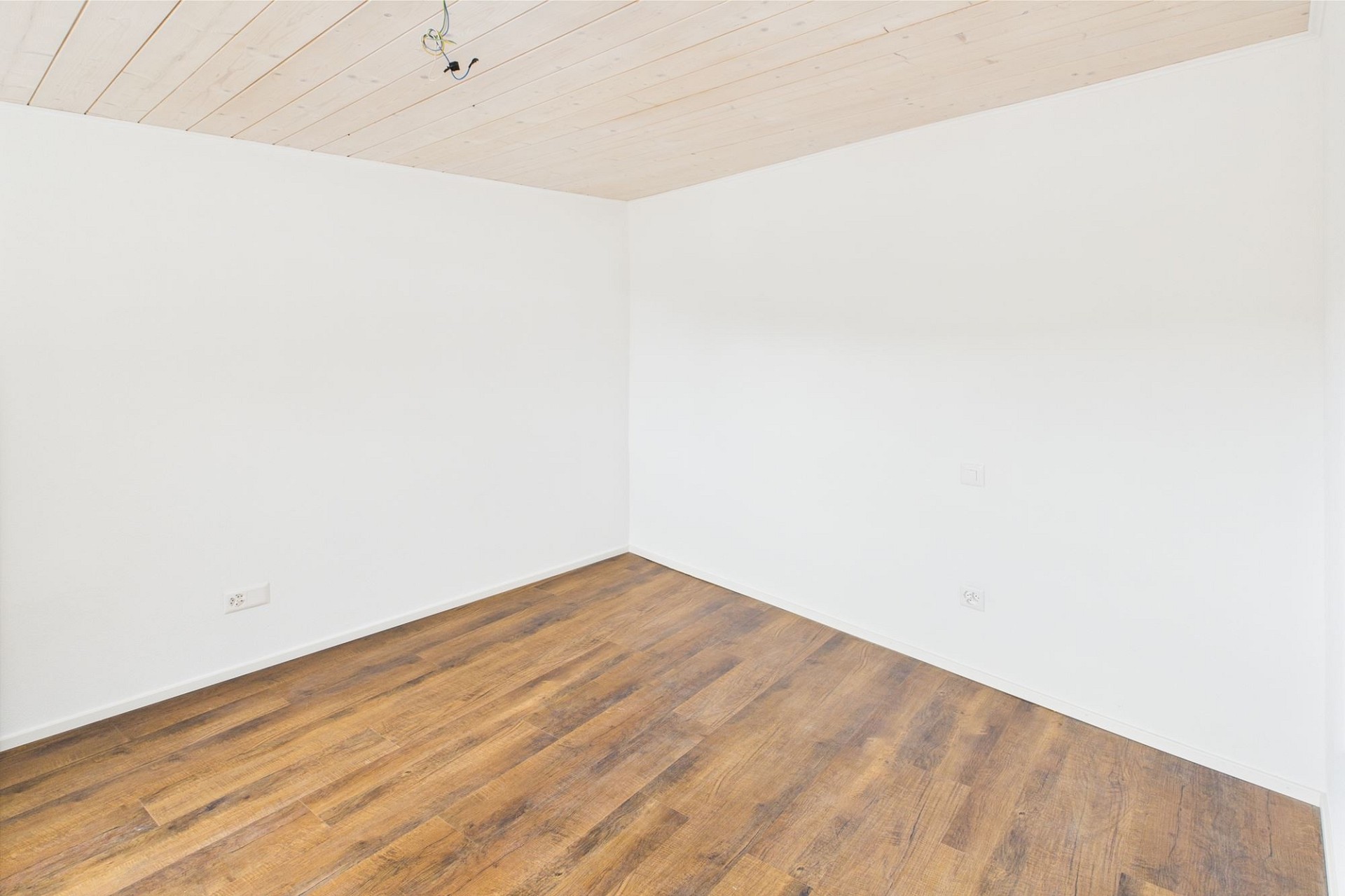 Leerer Raum mit Holzdecke und Holzoptikboden