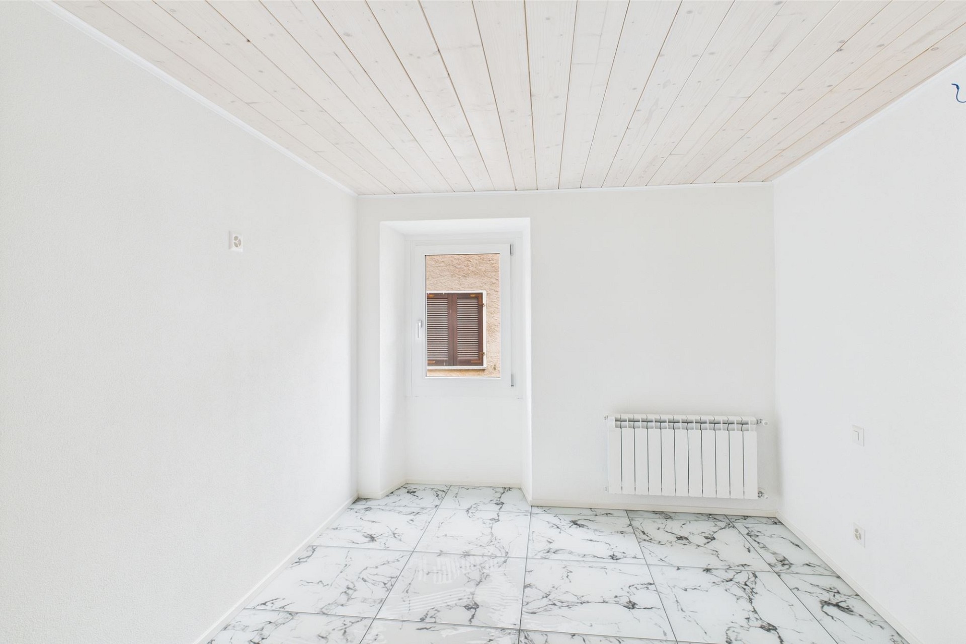 Heller leerer Raum mit Fliesenboden und Fenster