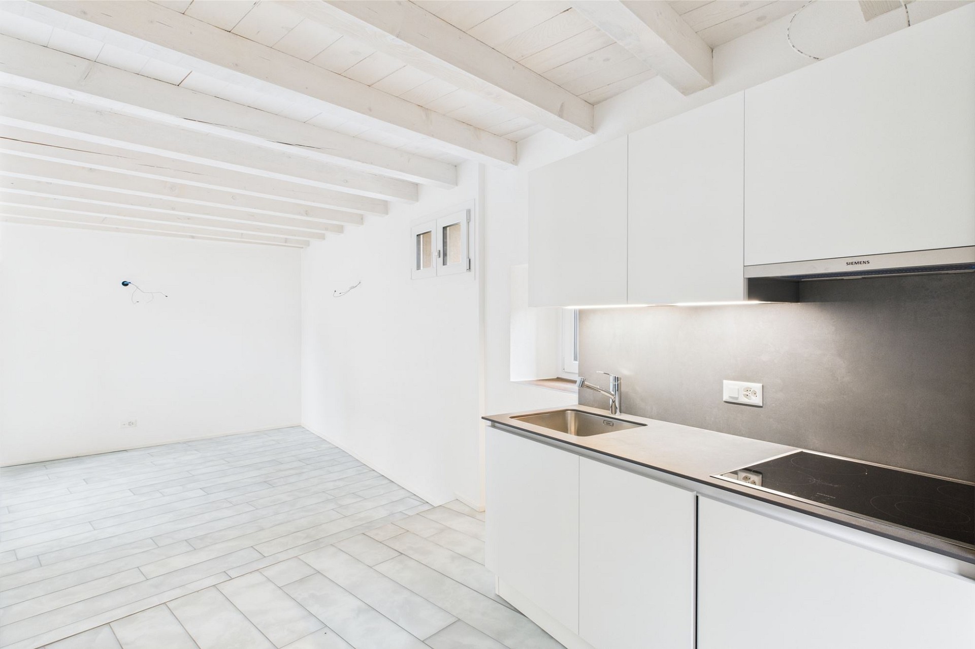 Helle, minimalistische Küche mit offenem Wohnbereich