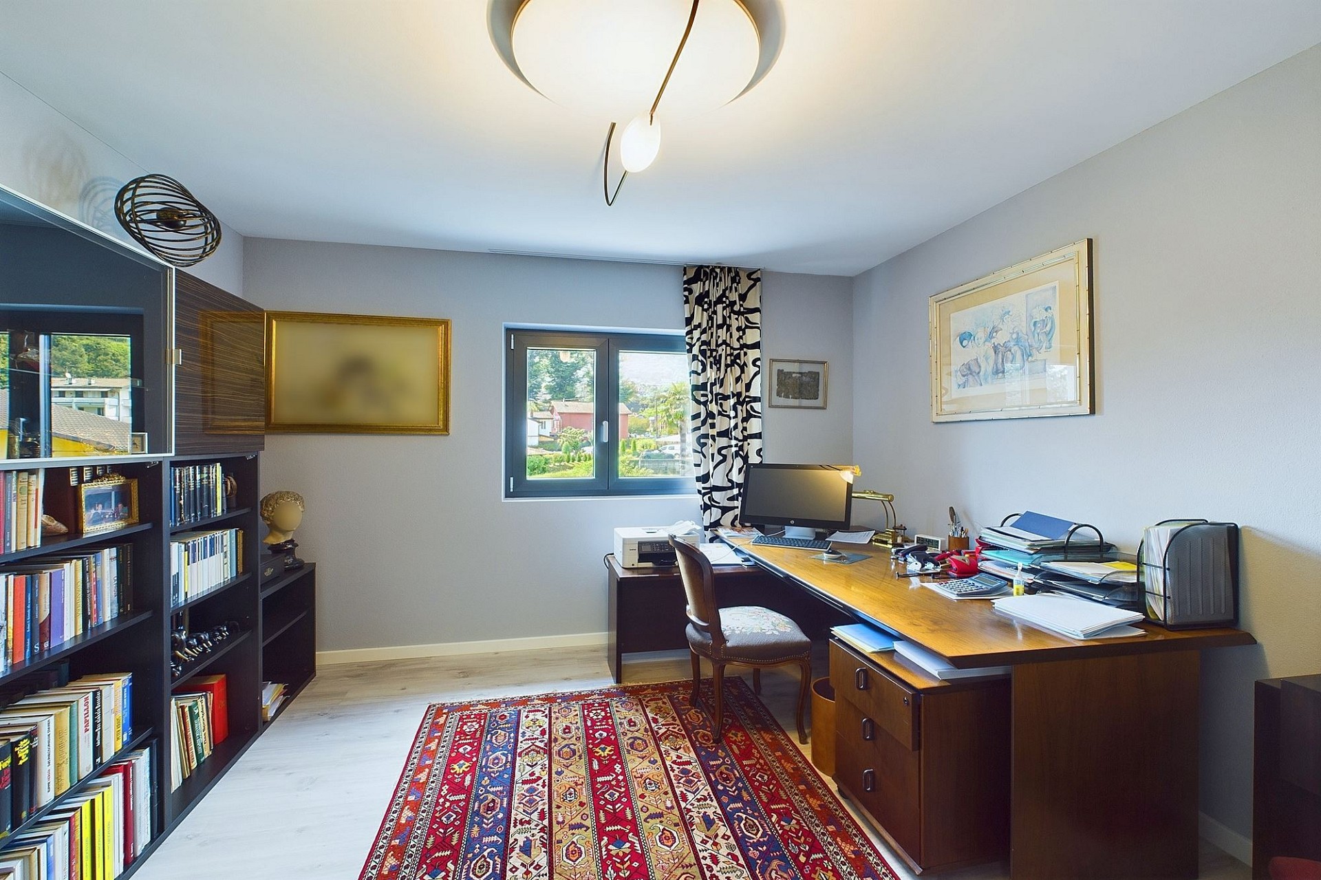 Arbeitszimmer mit Schreibtisch und Bücherregal