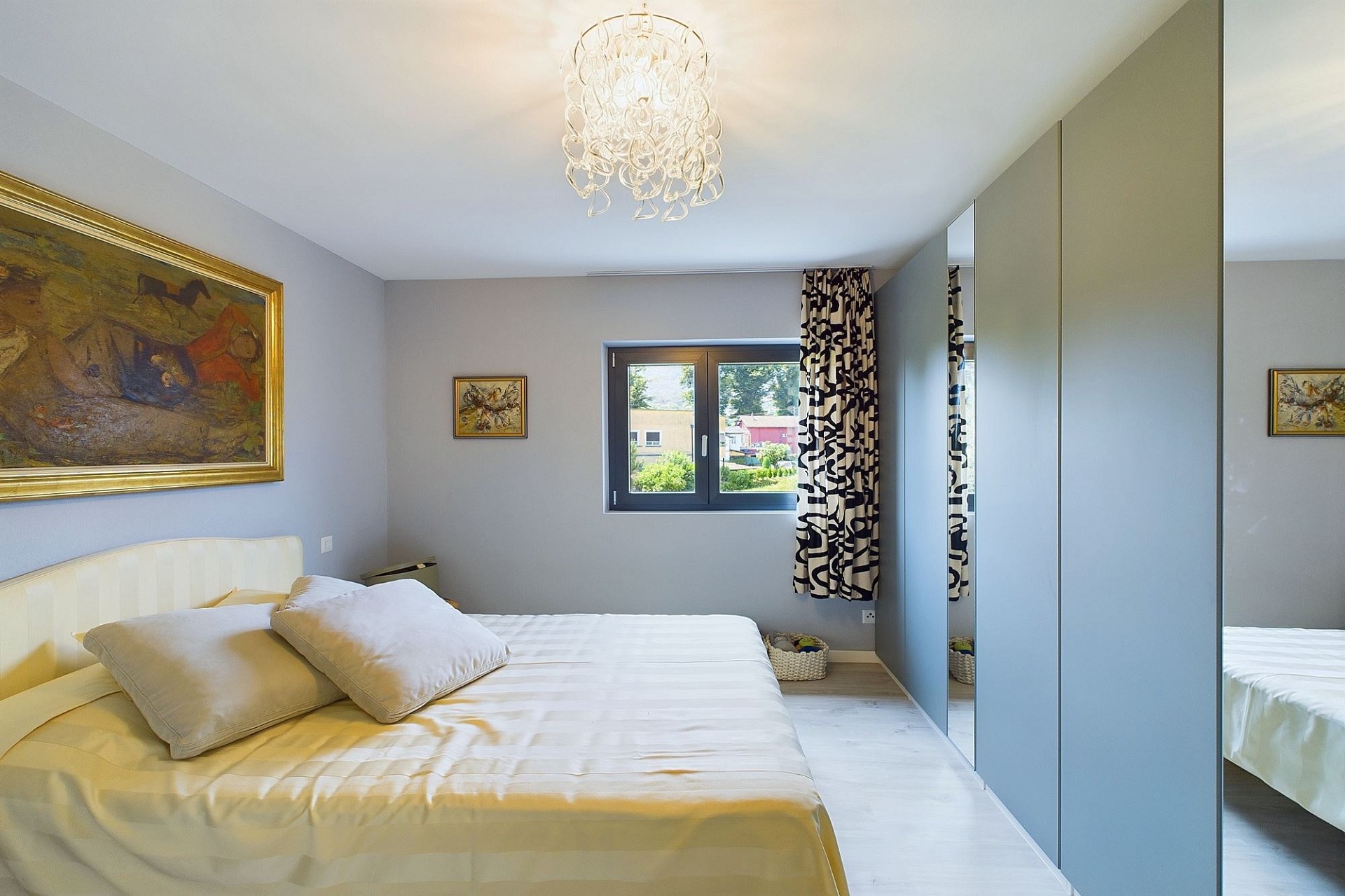 Helles Schlafzimmer mit Bett, Fenster und Spiegelkleiderschrank