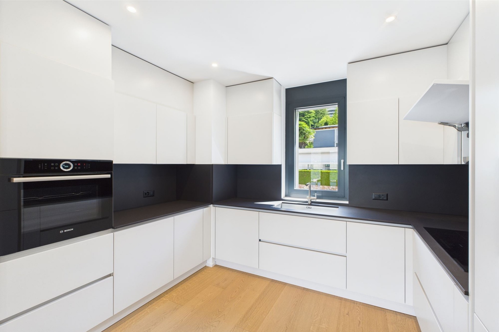 Moderne Einbauküche mit schwarzer Arbeitsfläche