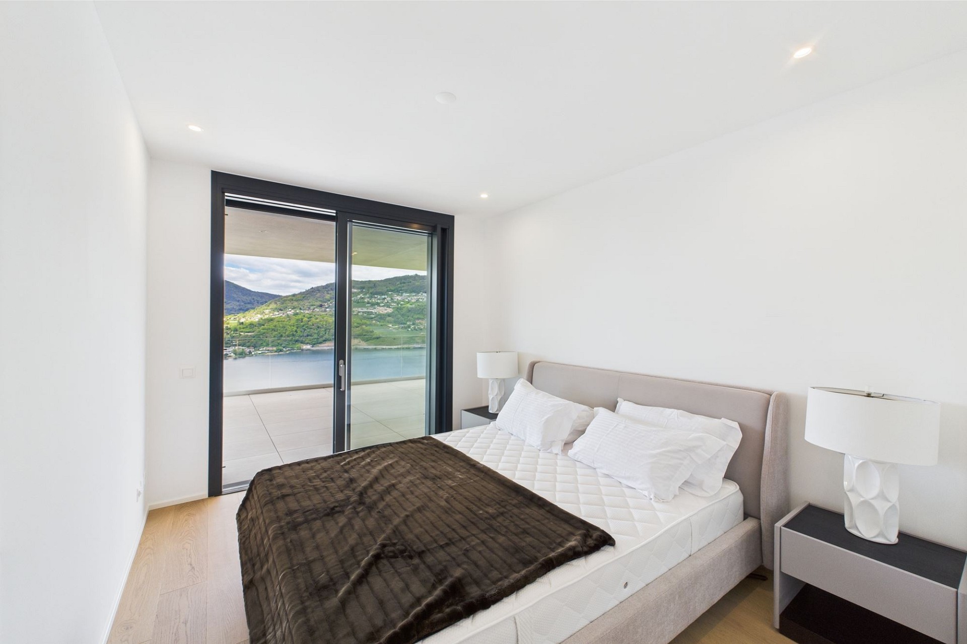 Modernes Schlafzimmer mit Balkon- und Seeblick