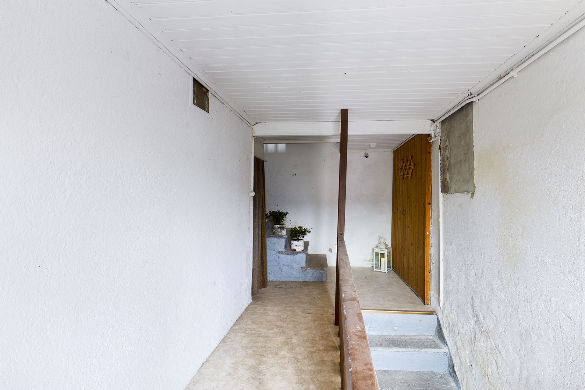 Schmaler Innenbereich mit Treppe und Holzpaneel-Tür