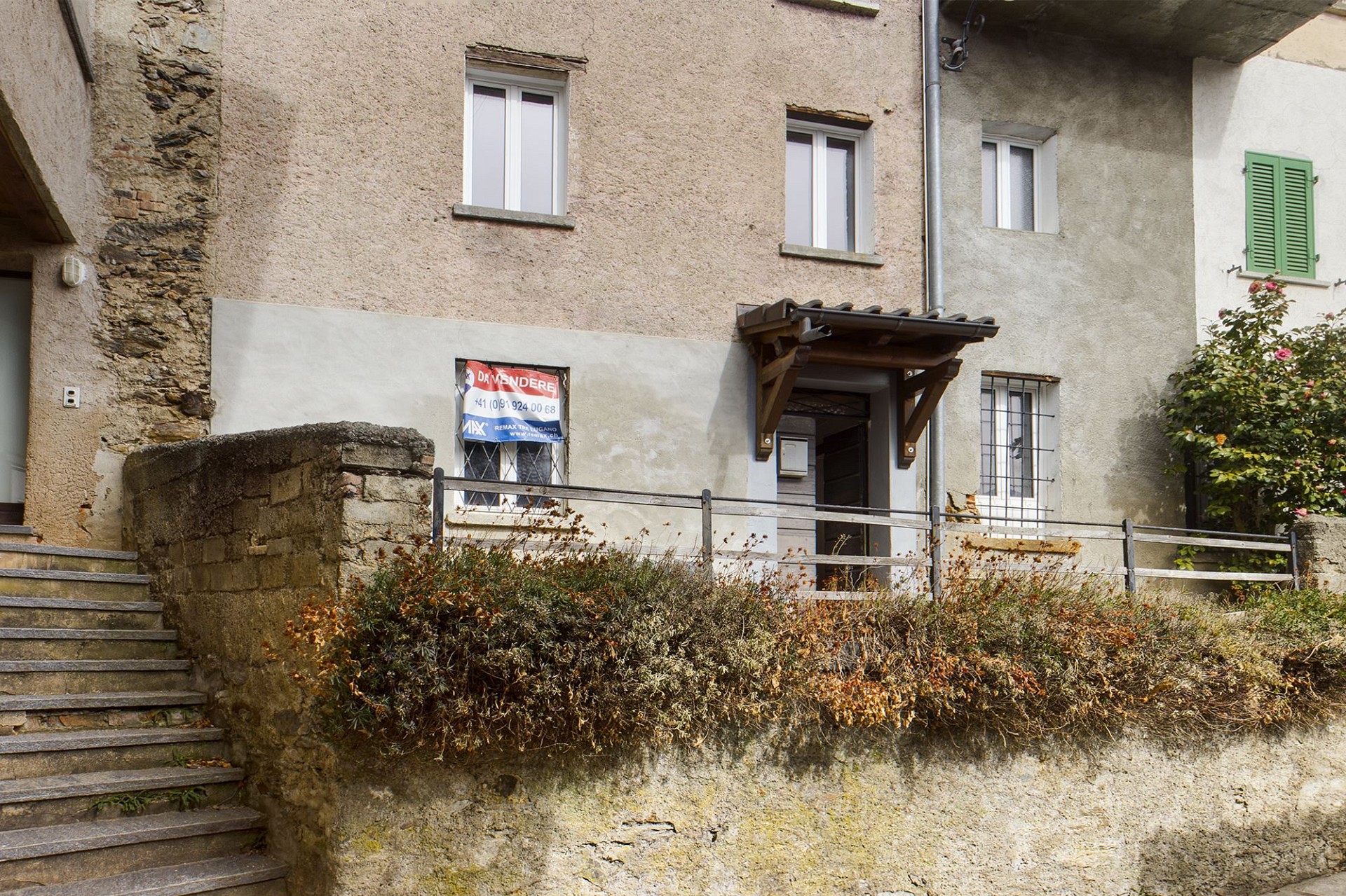 Außenansicht eines älteren Wohngebäudes mit Putzfassade und Fensterläden