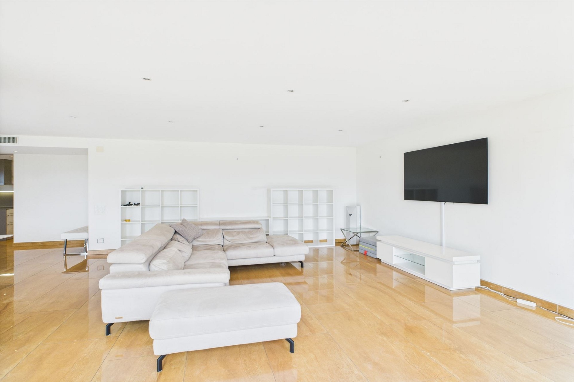 Helles, modernes Wohnzimmer mit großer Sitzgruppe und Wand-TV