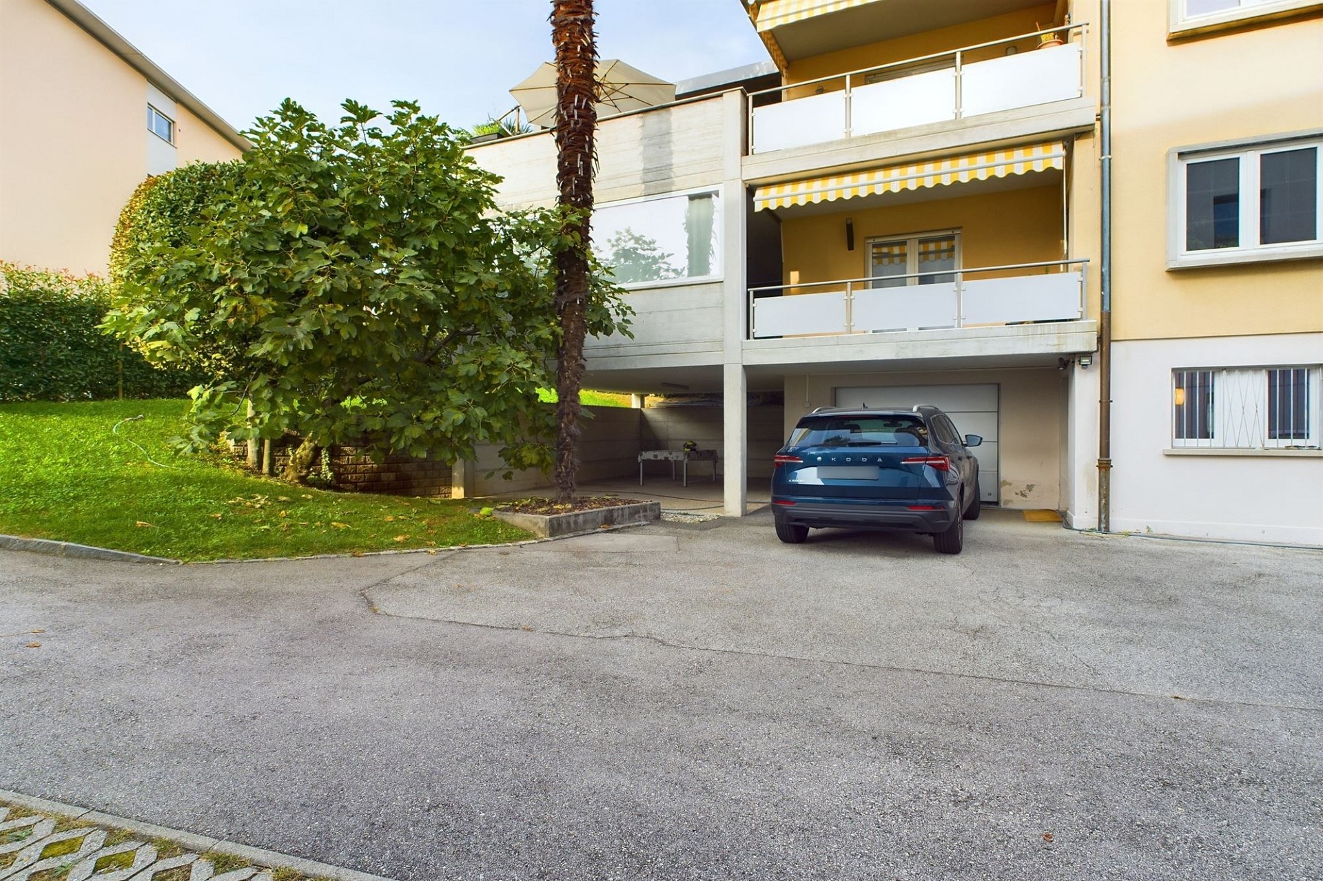 Außenansicht eines Mehrfamilienhauses mit Carport und Balkon