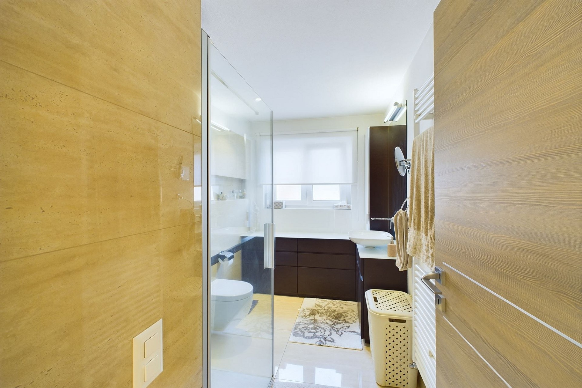 Helles, modernes Badezimmer mit Holzoptik und Glasdusche