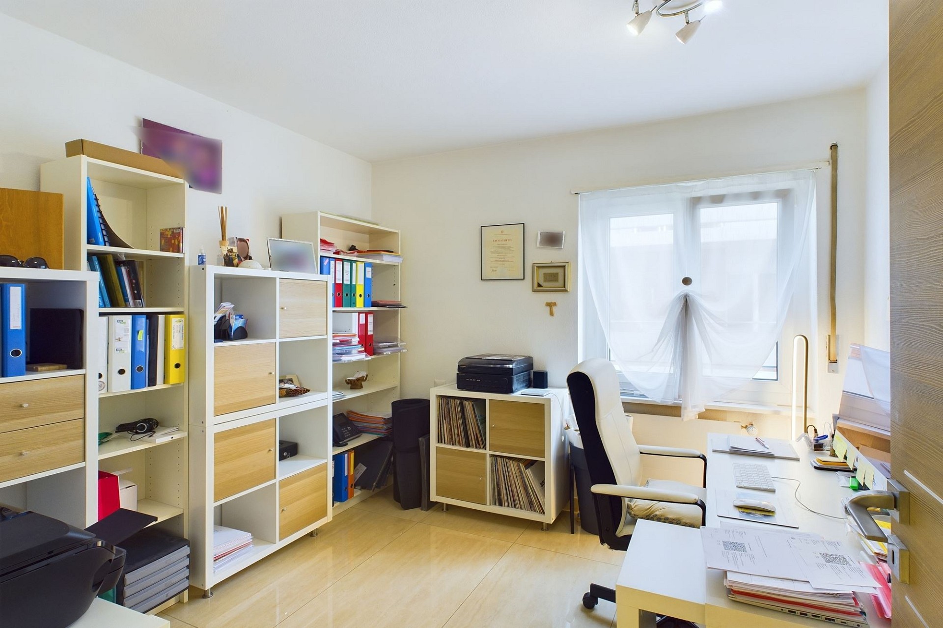 Helles Arbeitszimmer mit Regalen und Schreibtisch