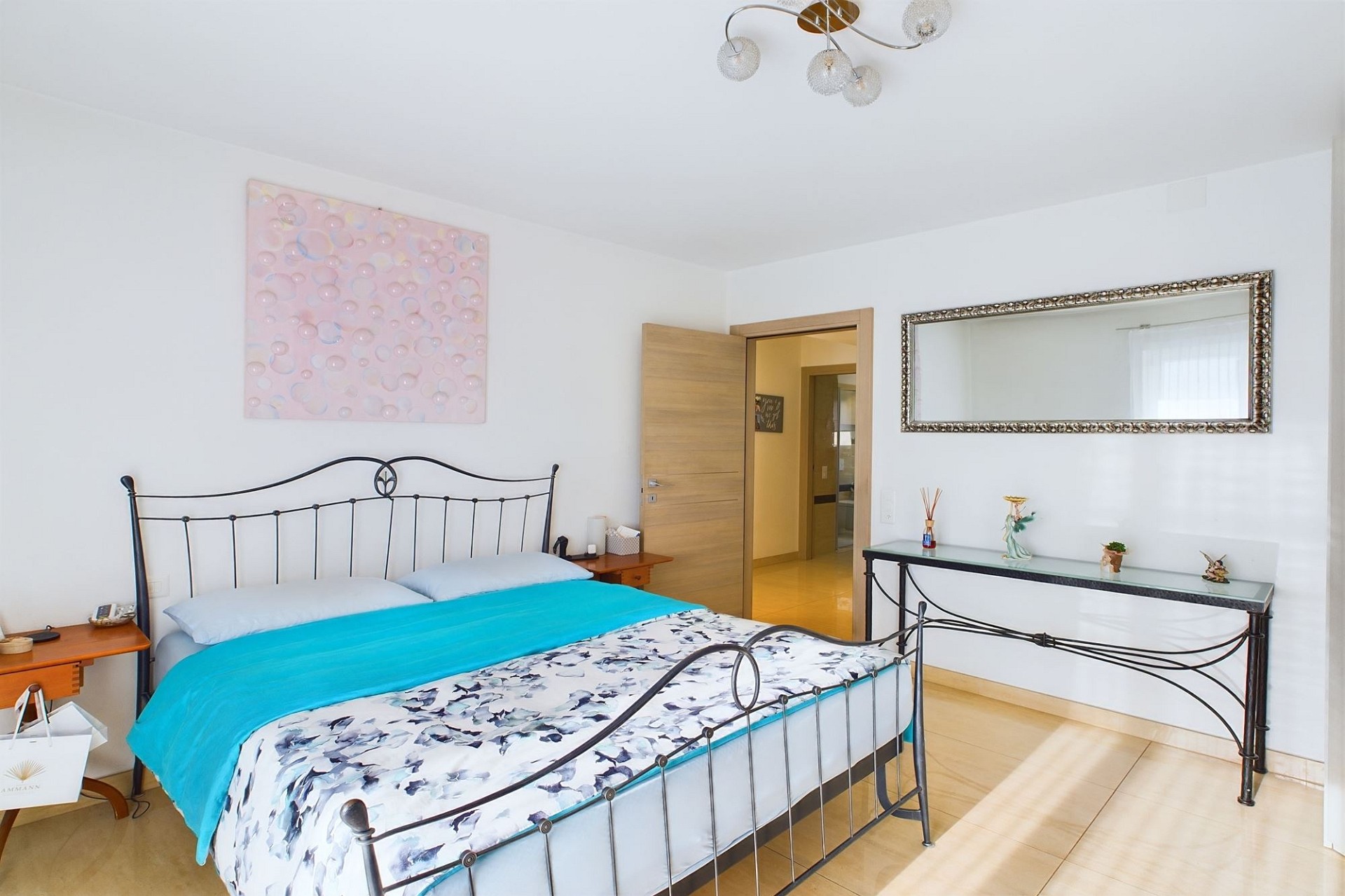 Helles Schlafzimmer mit Metallbett und Dekor