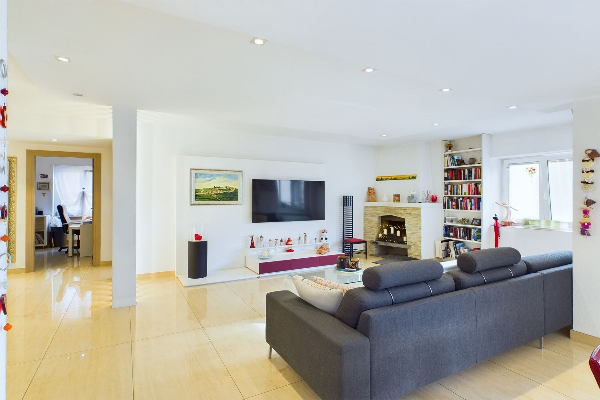 Heller Wohnraum mit Kamin und TV-Wand