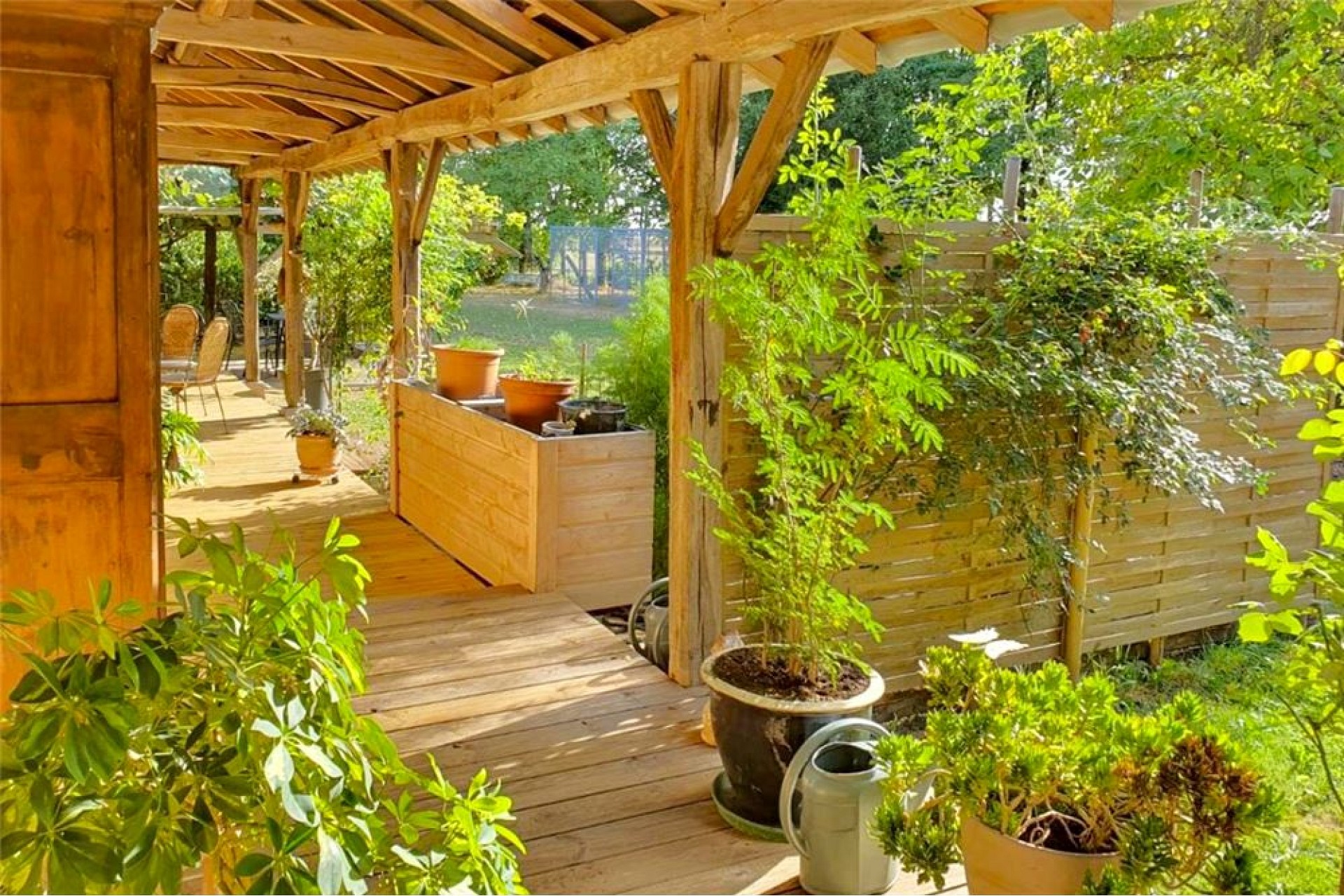 Überdachte Holzterrasse mit Gartenblick