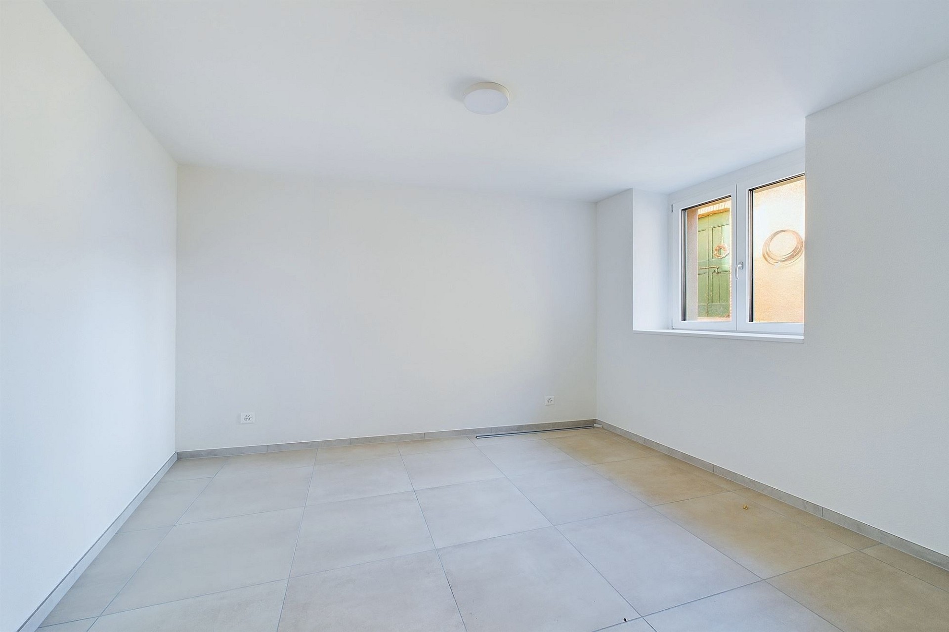 Leerer heller Raum mit Fliesenboden und Fenster