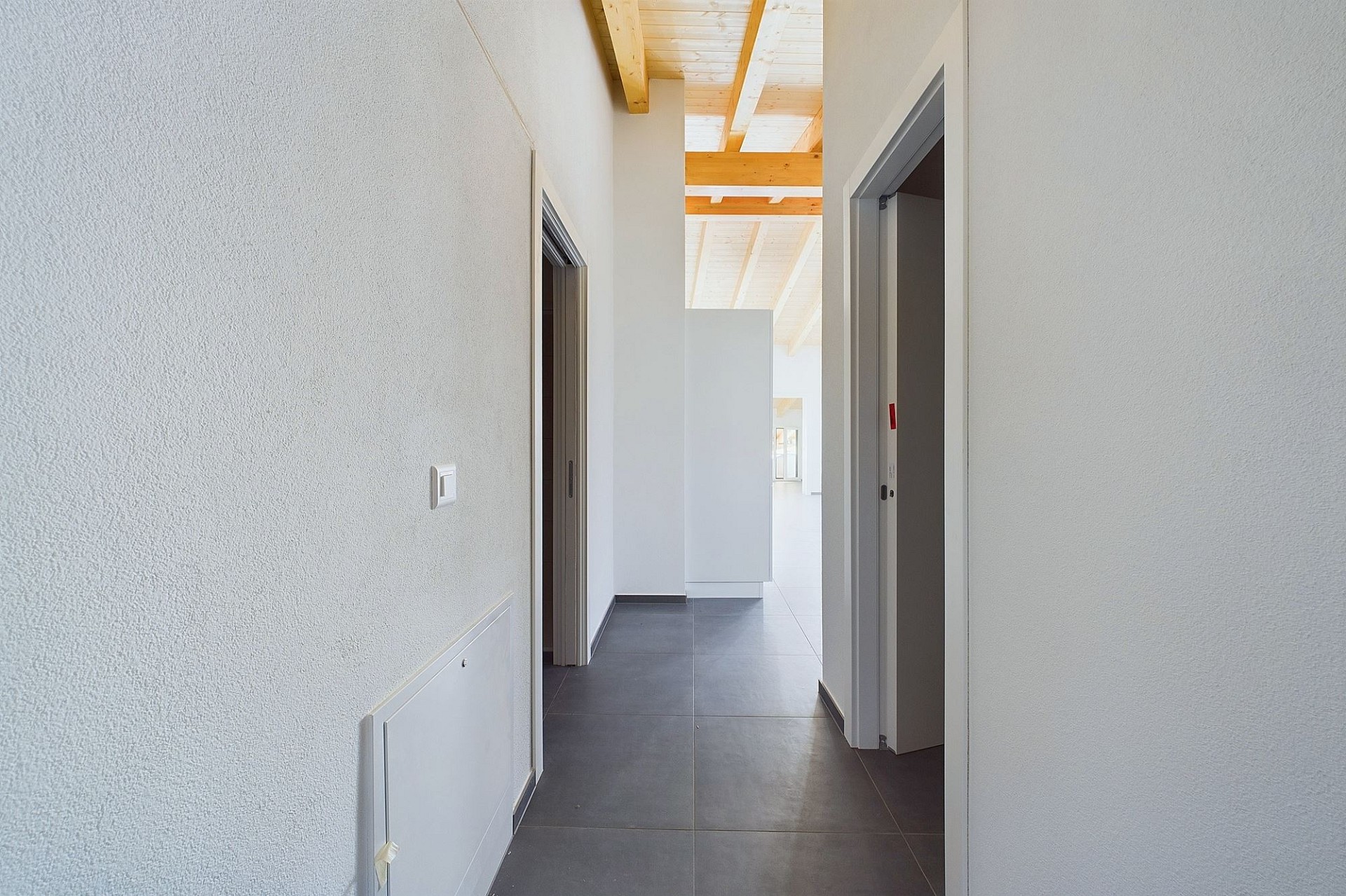 Heller Flur mit sichtbarer Holzbalkendecke
