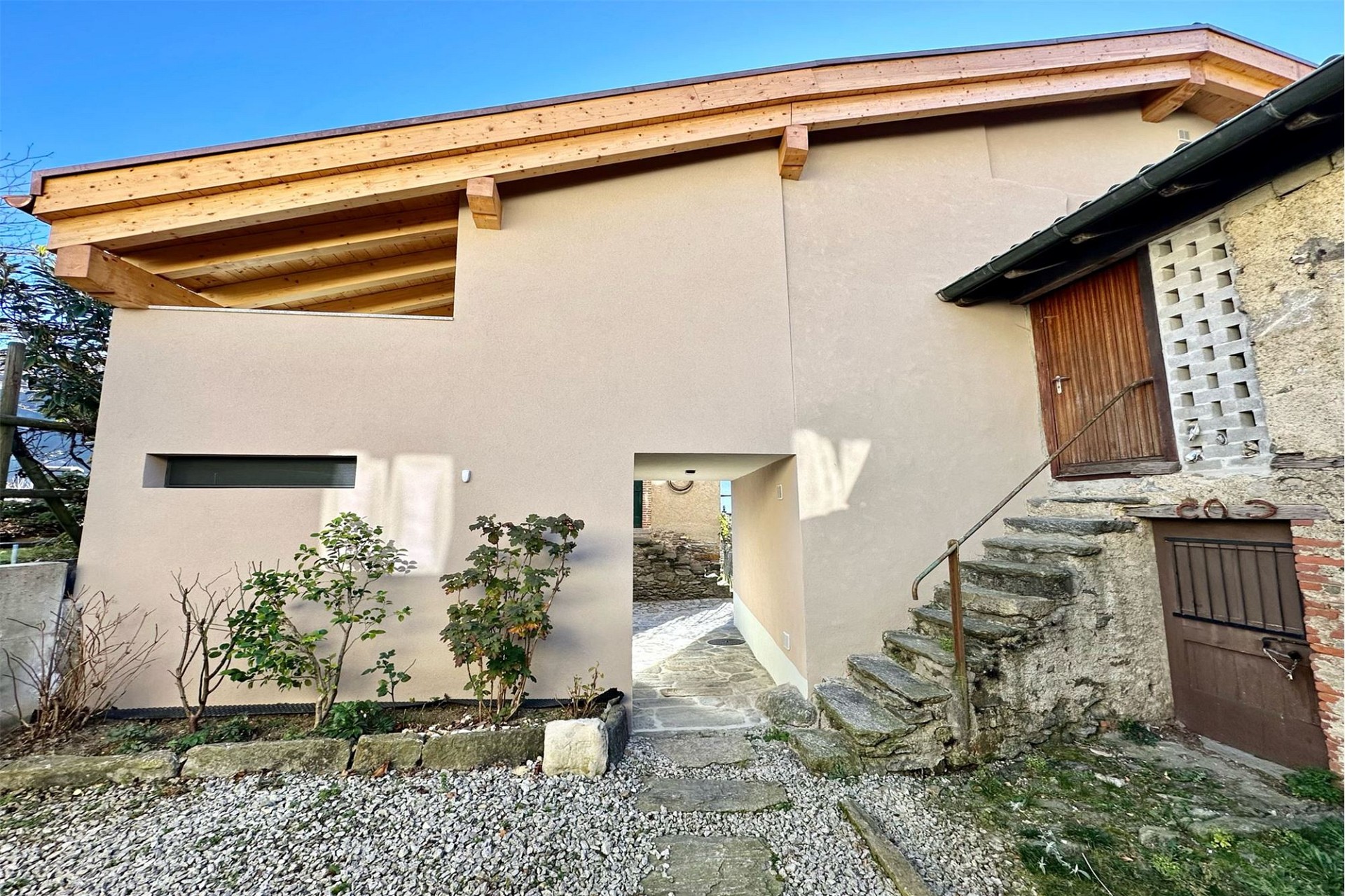 Außenansicht eines Hauses mit Holzgiebel und Natursteintreppe