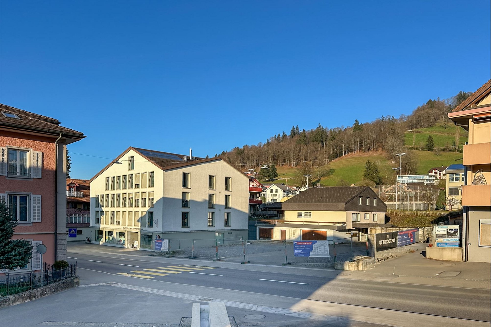 Straßenansicht eines Wohn- und Geschäftshauses in sonniger Lage