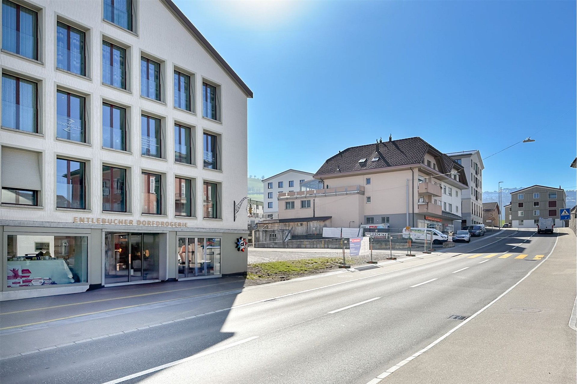 Straßenansicht eines Wohn- und Geschäftshauses an einer sonnigen Straße