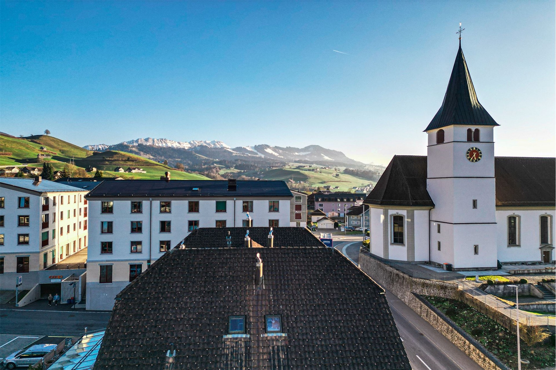 Dorfansicht mit Kirche und Bergpanorama